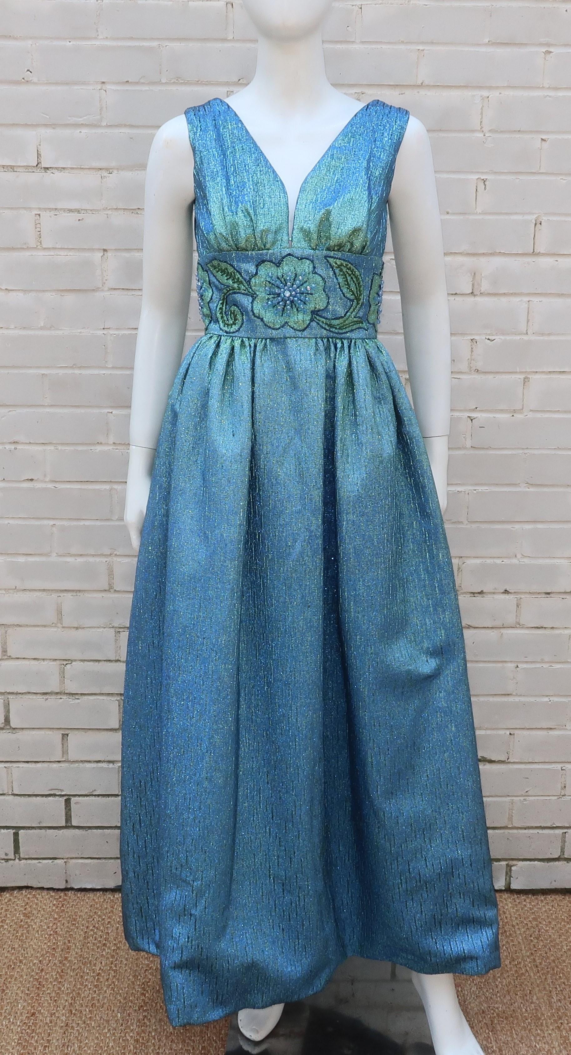 1960's Jean of California evening dress with a sparkling metallic fabric in an eye-catching iridescent green and blue.  It zips and hooks at the v-back with a cummerbund style waist which is decorated with a floral design accented by light blue and