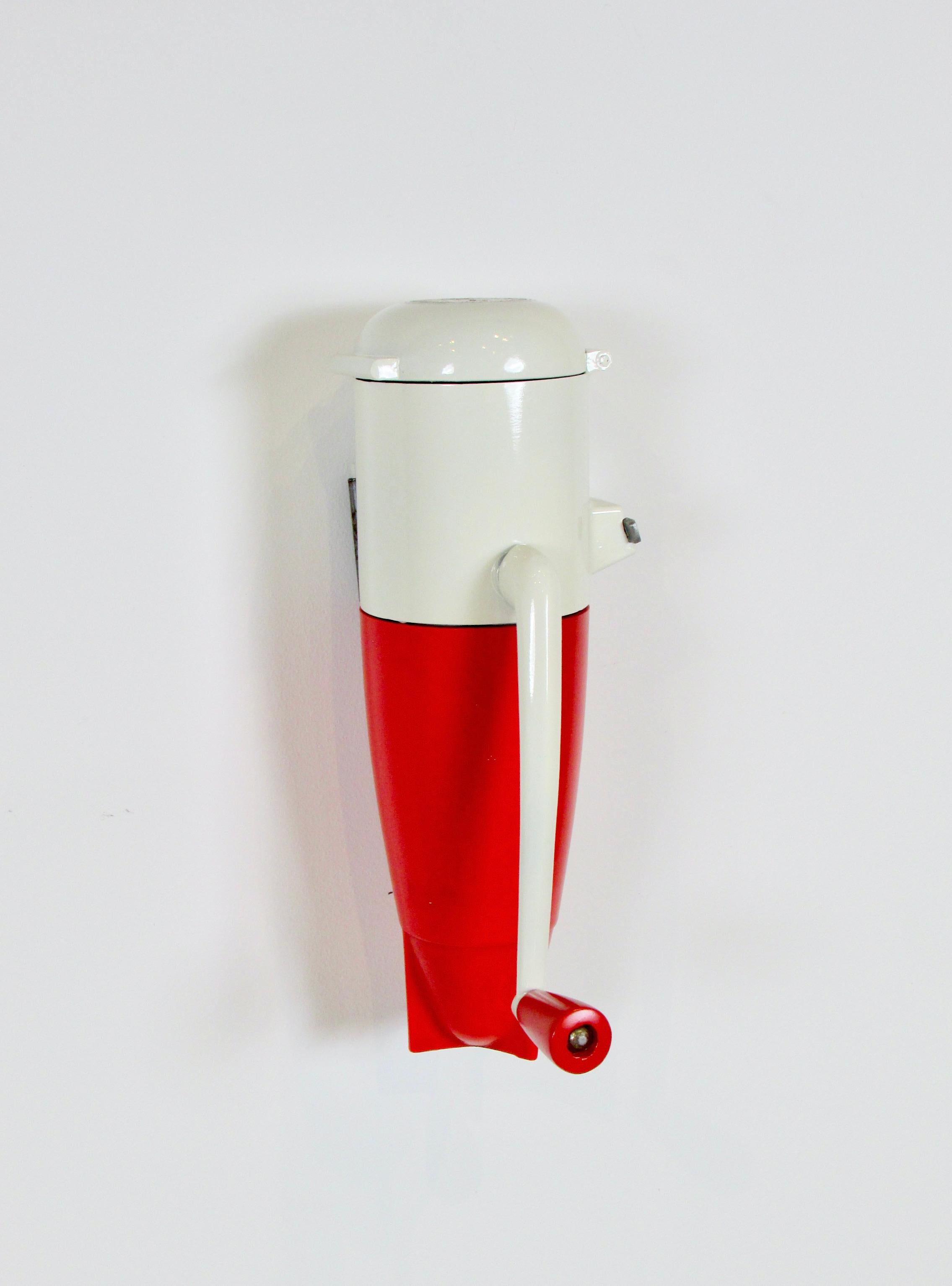 Streamlined wall mount Dazey ice crusher. Designed by Jean Otis Reinicke for Dazey Churn and Nfr. Co. 1938. Upper body has been refinished . Retains partial water decal on top of lid . Red plastic base is original and in fine condition . Wall mount