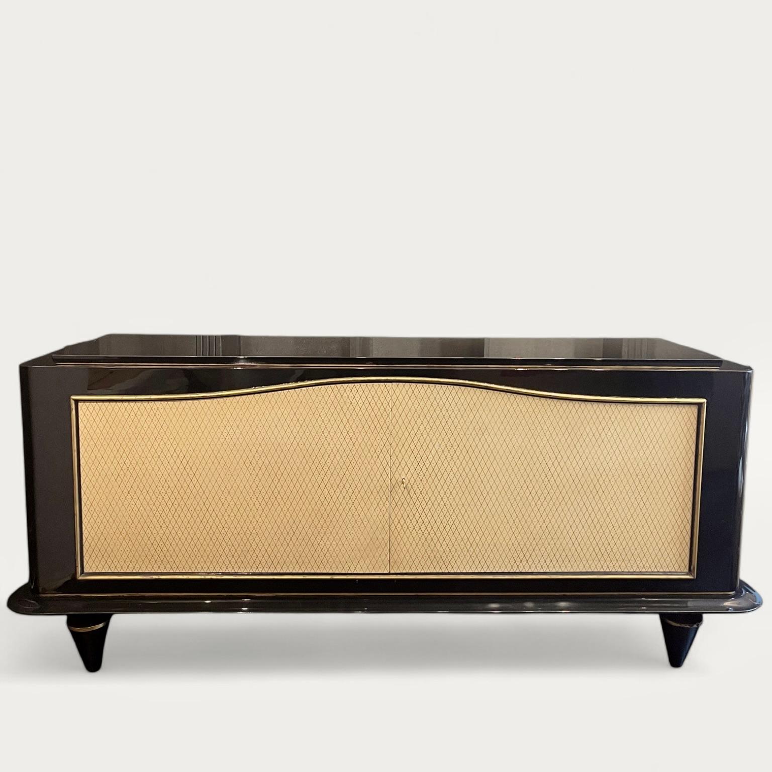 A remarkable black and cream lacquered Jean Pascaud sideboard, circa 1940. 

The body, finished in the deepest of black lacquers contrasts beautifully with the cream lacquered doors, indented with a diamond and dot pattern. Simple gold bands of
