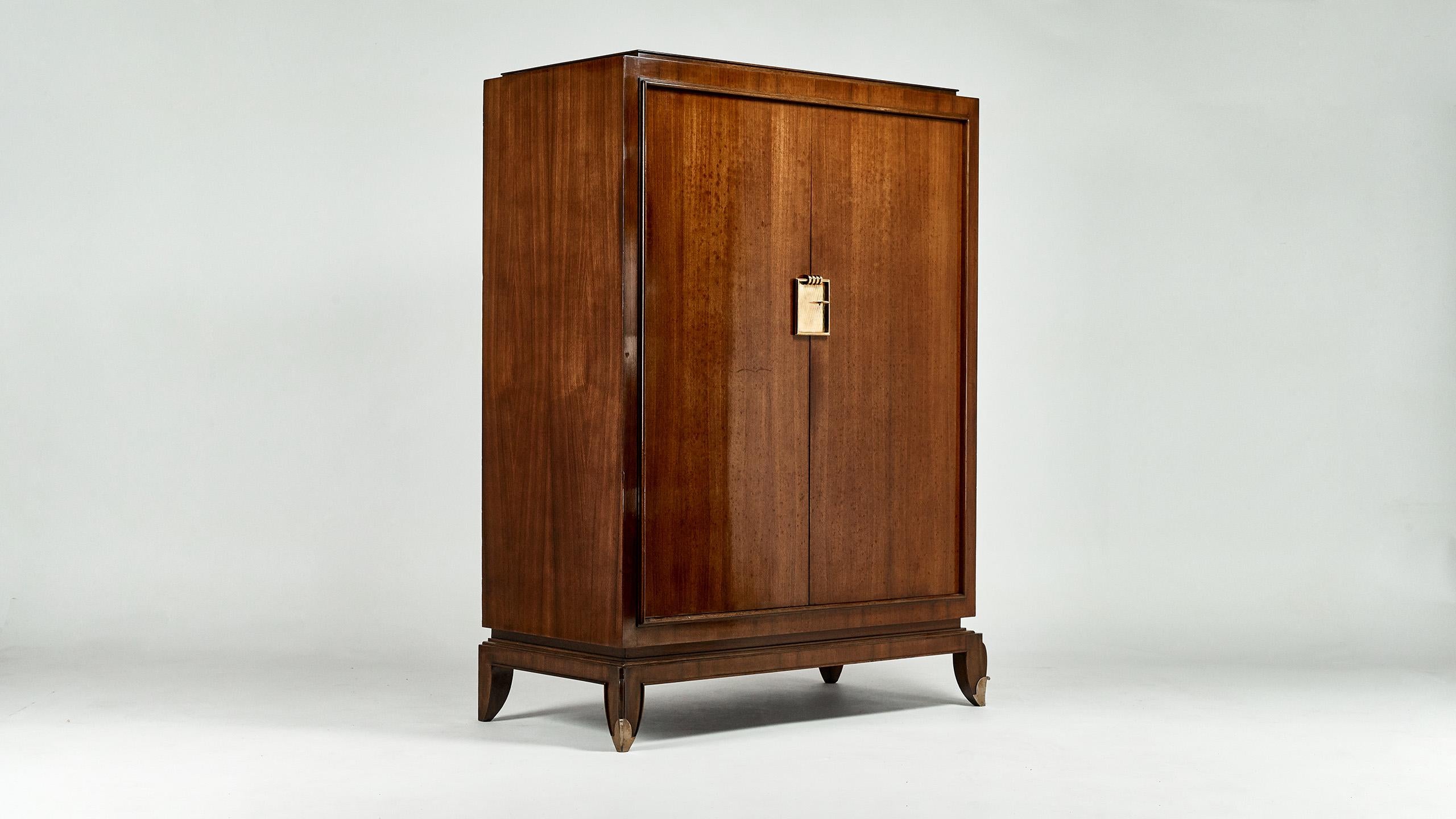 Exceptional neoclassical wardrobe, by French decorator Jean Pascaud, in rosewood and rosewood veneer enhanced with gilded bronze. 

Opening by two doors, revealing wardrobe, shelf and drawers. 

Patina and traces due to age and use, very good