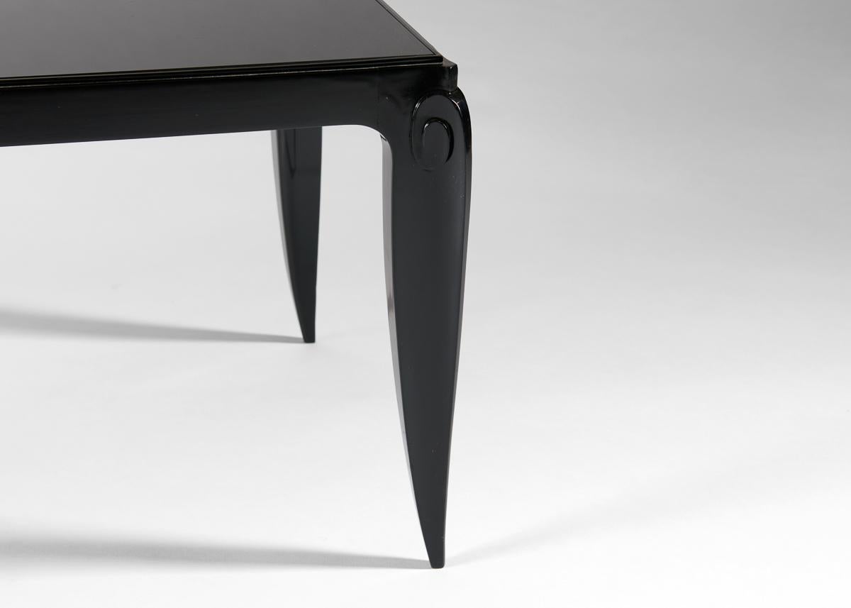 Niedriger, schwarzer Tisch mit Glasplatte und sich leicht verjüngenden Beinen, charakteristisch für den französischen Deco-Meister.