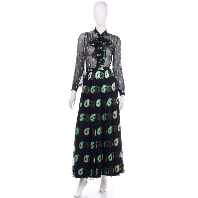 This 1970's sensational vintage 2 piece dress from Jean Patou is in a luxurious fine black silk and is covered with paisleys  and dots in gold and green metallic thread. The dress has a sheer blouse with front covered buttons, and a tie and snaps at