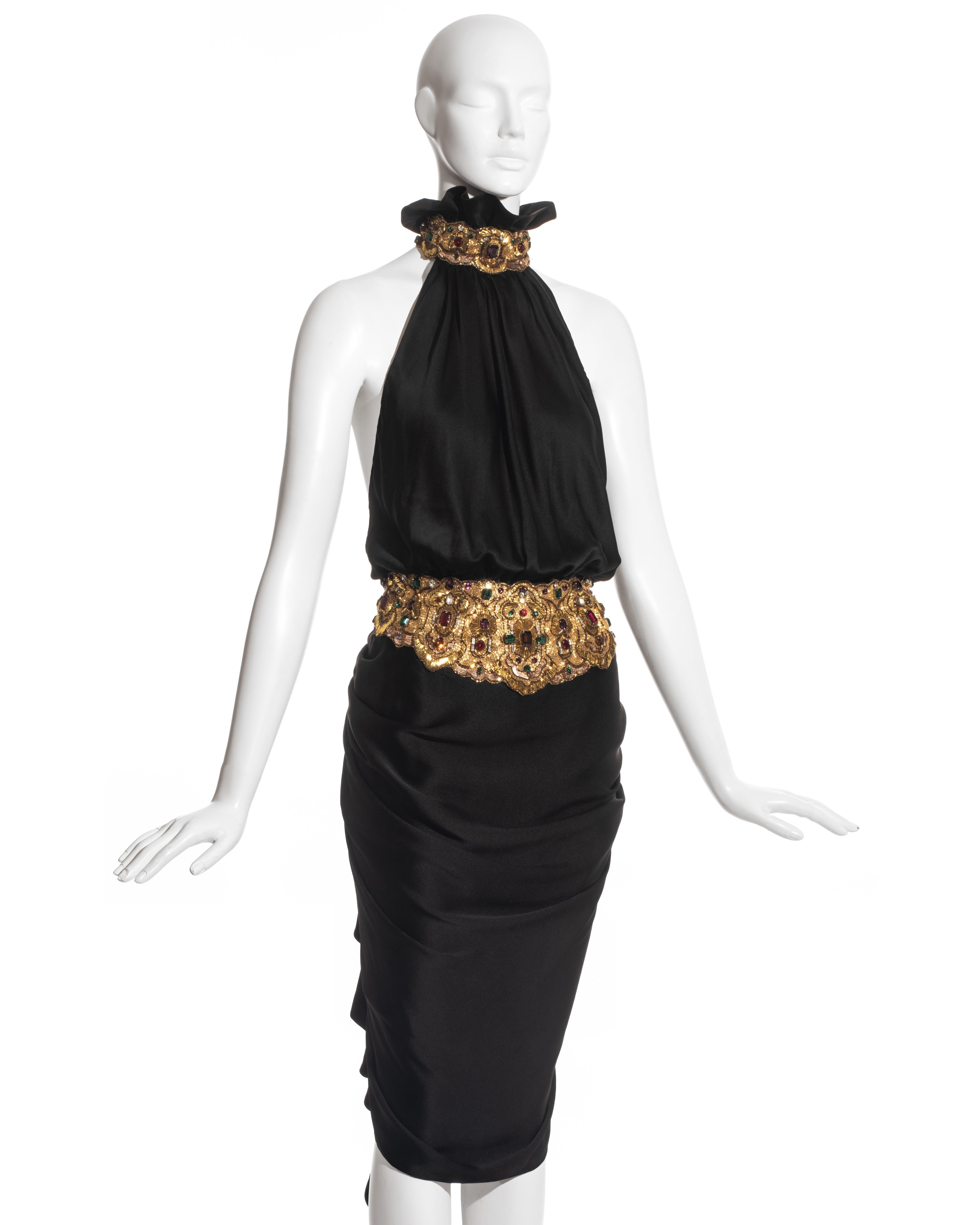 Jean Patou by Christian Lacroix black silk cocktail dress with halter neck ruffled collar, gold tone metal embroidery with clear, ruby and emerald coloured gems, horizontal drapes on front of the skirt forming into a knotted hanging sash at the