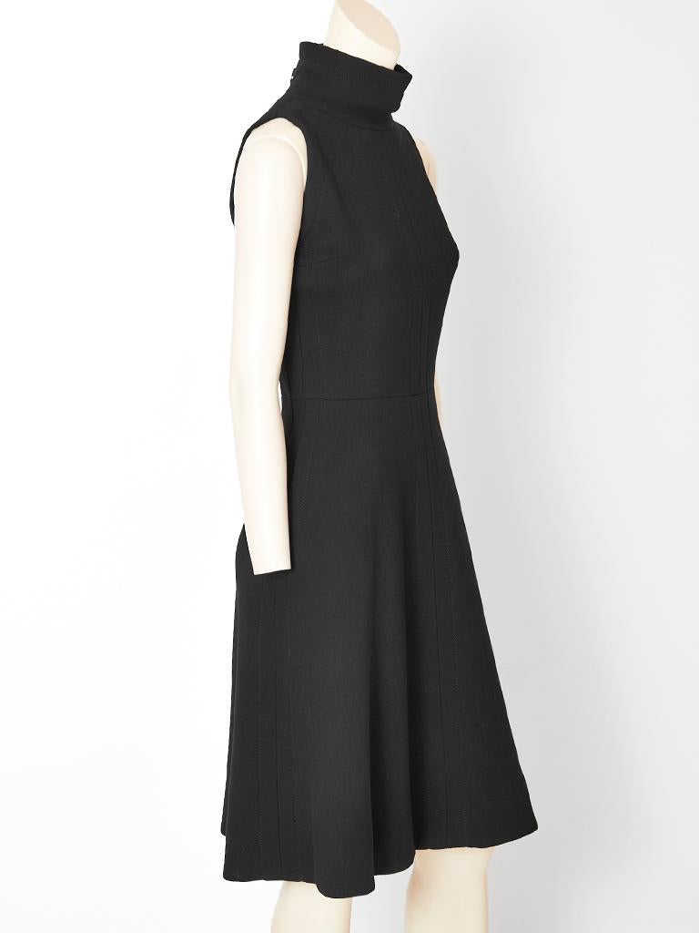 Jean Patou, sleeveless,  A line, turtleneck, dress in a heavy wool crepe creating a sculptural silhouette. Dress has top stitching detail down the center front, sides and hem. C. 1960's.

