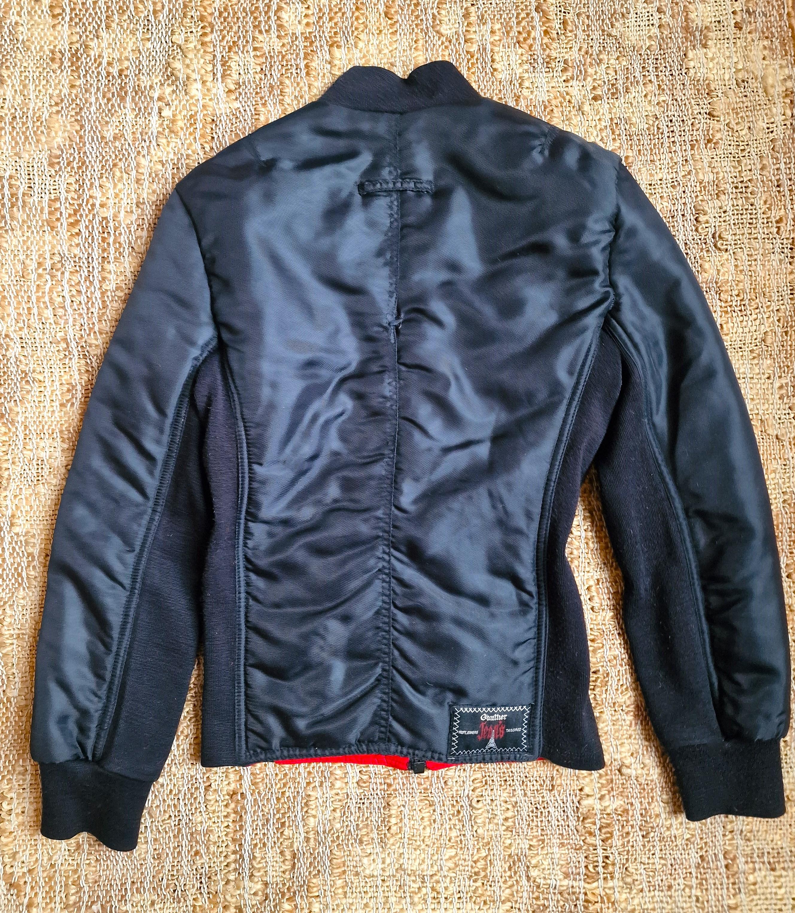 Black nylon 6-pack muscle puffer jacket by Jean Paul Gaultier! 

A unique find from the Gaultier Jeans line, this nylon puffer jacket features knit details and six front pockets positioned to replicate 6-pack abdominal muscles.
Crew neck
Six flap