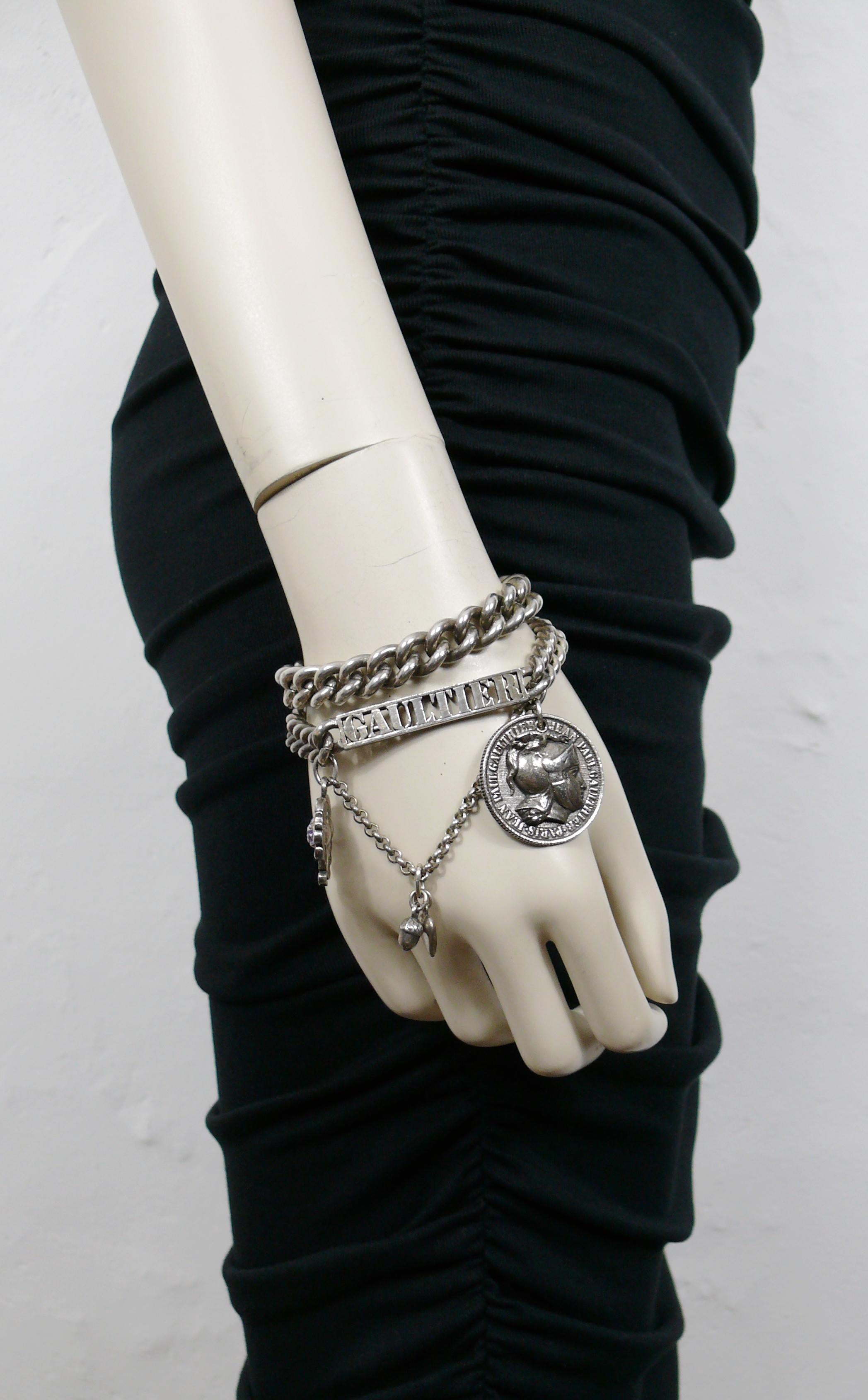 JEAN PAUL GAULTIER antiqued silver toned curb chain bracelet featuring cut-out GAULTIER ID tag and charms  : jewelled thistles, heart, acorn, Roman centurion coin.

Silver tone metal hardware.
Antiqued patina.

Secure hoop clasp closure.

Embossed