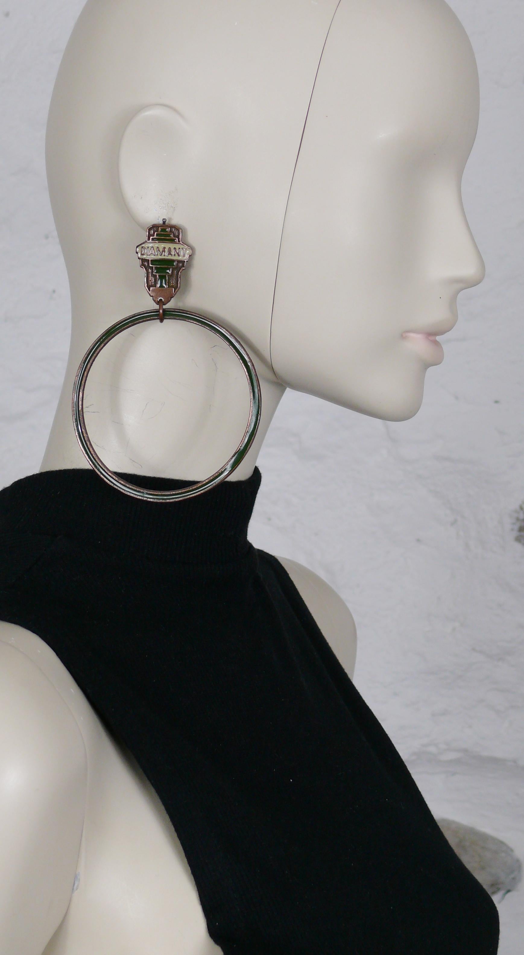 JEAN PAUL GAULTIER vintage Art Deco inspired oversized hoop earrings with DIAMANT inscription. Green and off-white enamel overlay on copper toned metal.

Embossed JPG.

Indicative measurements : height approx. 11 cm (4.33 inches) / hoop diameter