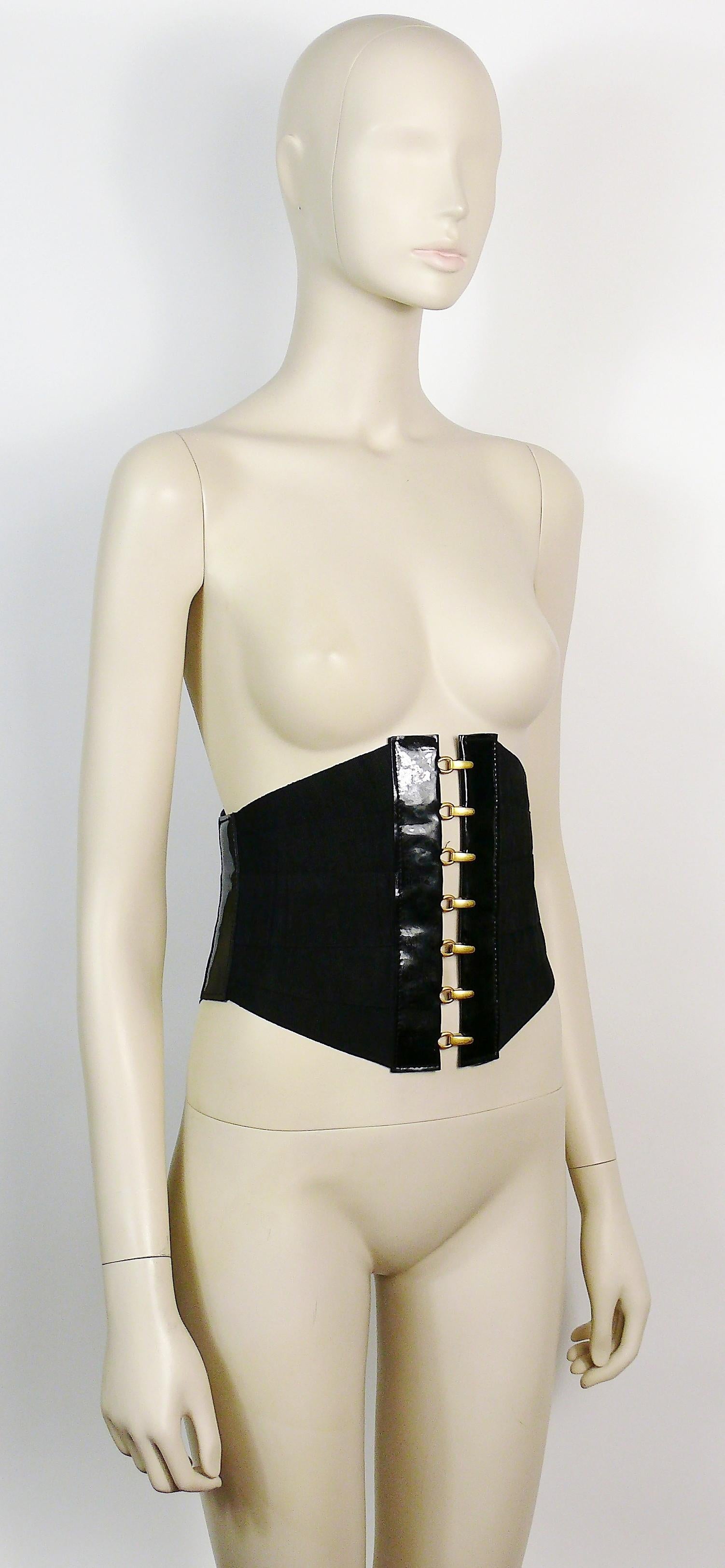 Vintage black bandage corset belt made of grosgrain straps, patent leather details and gold toned hardware.

Hook and eye front closure.
Laces on back.
Piercing ring detail on left side.

No indicated size.

Un-marked.

Indicative measurements :