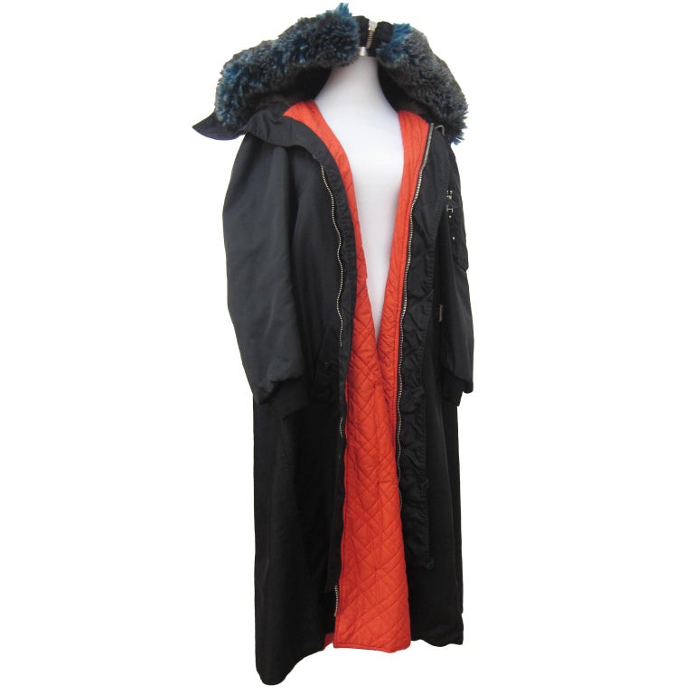 An early, rare Jean Paul Gaultier black bomber jacket / a-line coat from circa 1980s.
Over sized blue and brown shade faux fur hooded coat gives beautiful volume. With bright orange lining with pockets. Fits like Medium. 