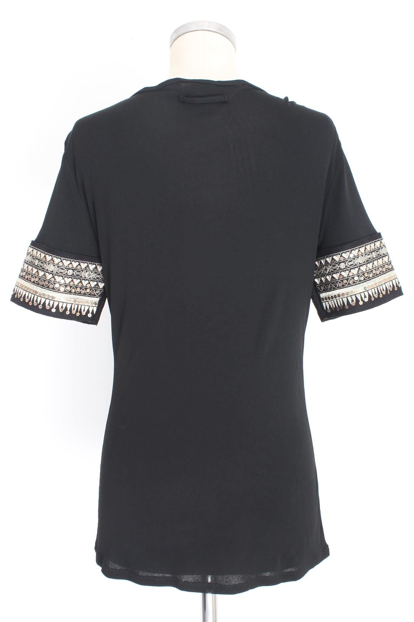 Jean Paul Gaultier 2000s T shirt. Long shirt, black, embellished on the sleeves with gold-colored embroidery and sequins, along the chest part in leather with studs. 100% rayon, 100% sheepskin fabric. Made in italy.

Size: 44 It 10 Us 12