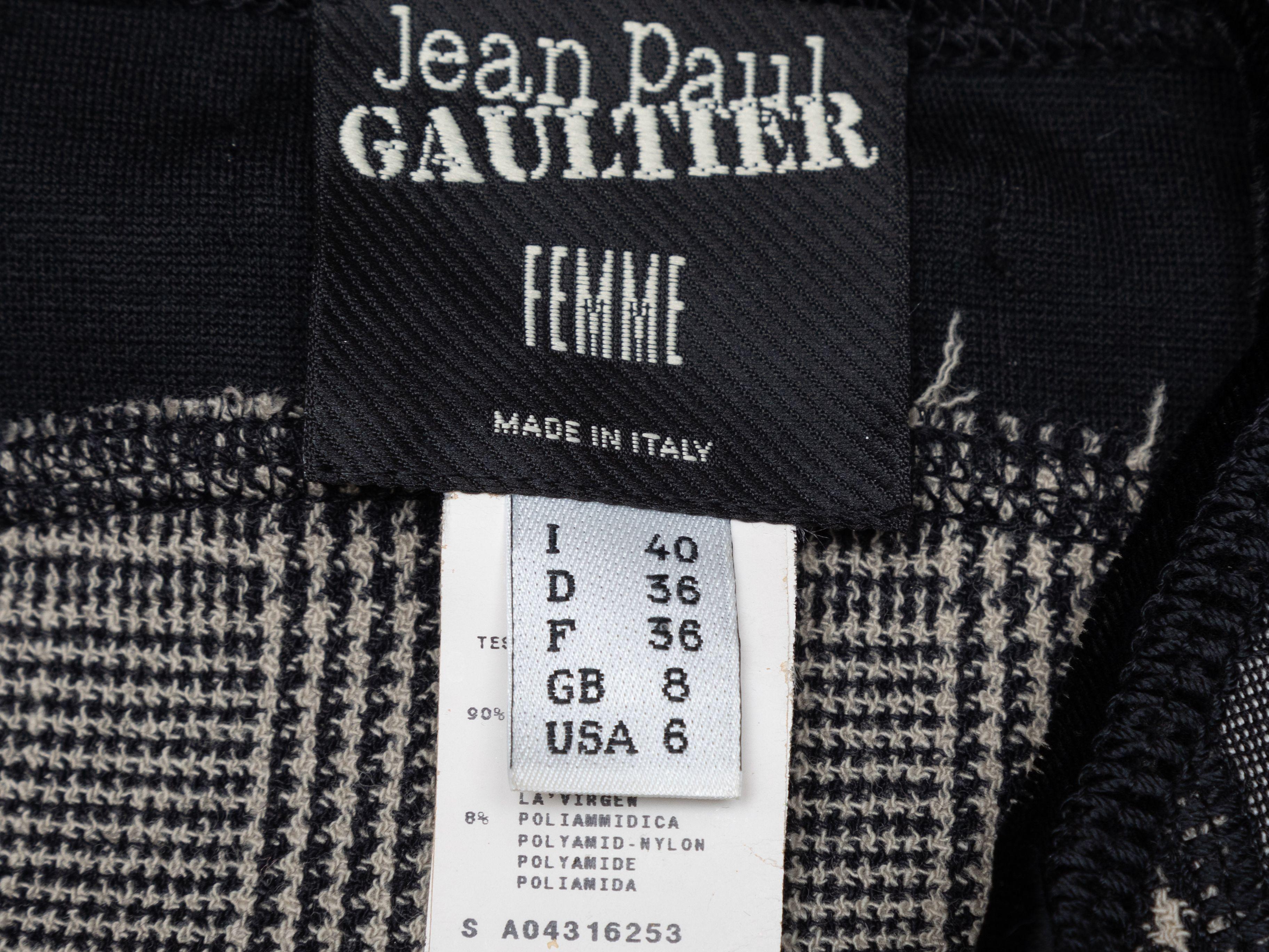 Product Details: Black and grey virgin wool houndstooth vest by Jean Paul Gaultier. Crew neck. Belt at waist. Zip closure at center front. 28