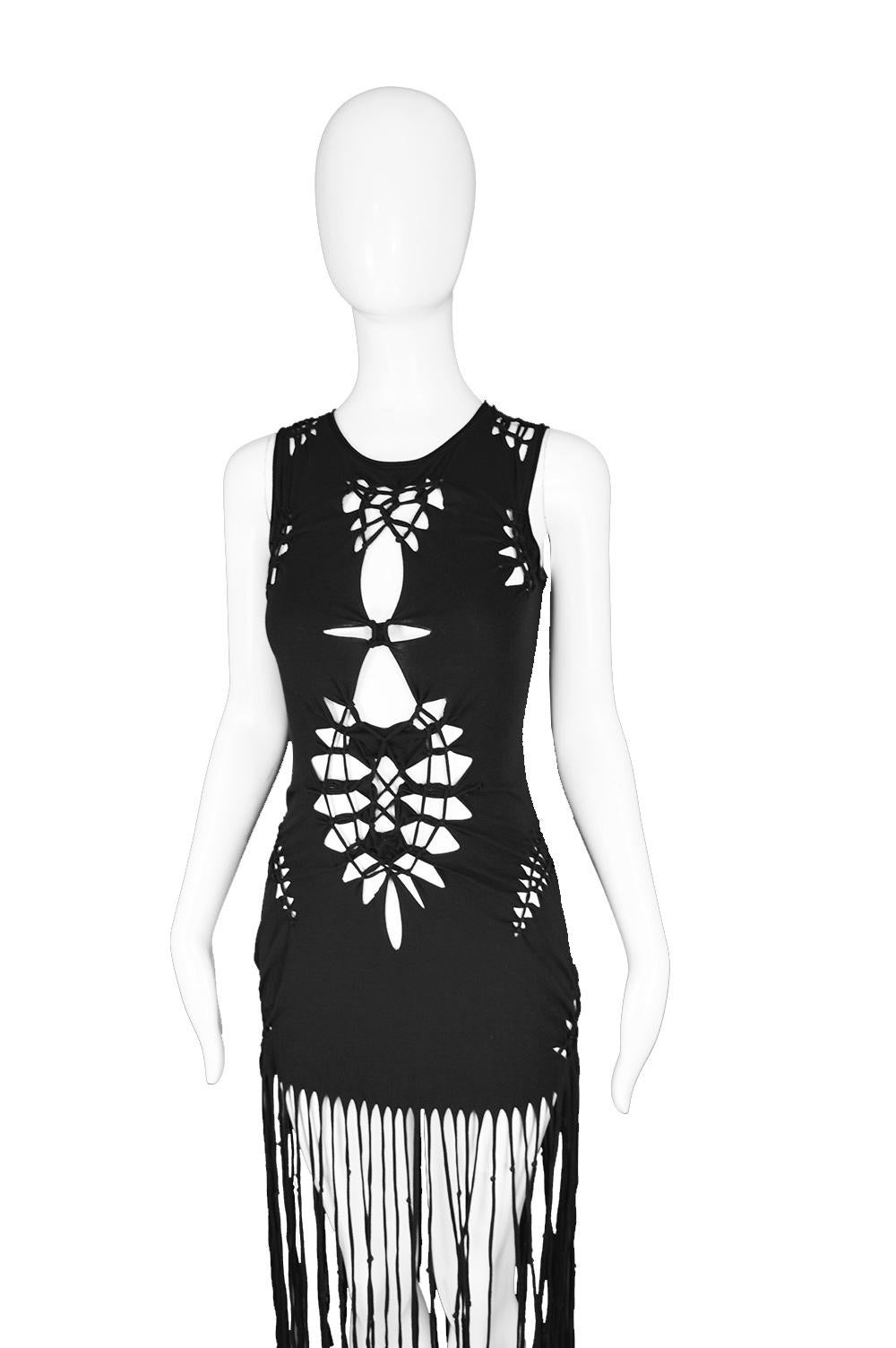 A fabulous women's sleeveless dress by iconic French fashion designer, Jean Paul Gaultier from the Spring Summer 2001 collection. In a black stretch cotton jersey with cut out macrame / knotwork details and fringes to create a tough, gothic hippie /