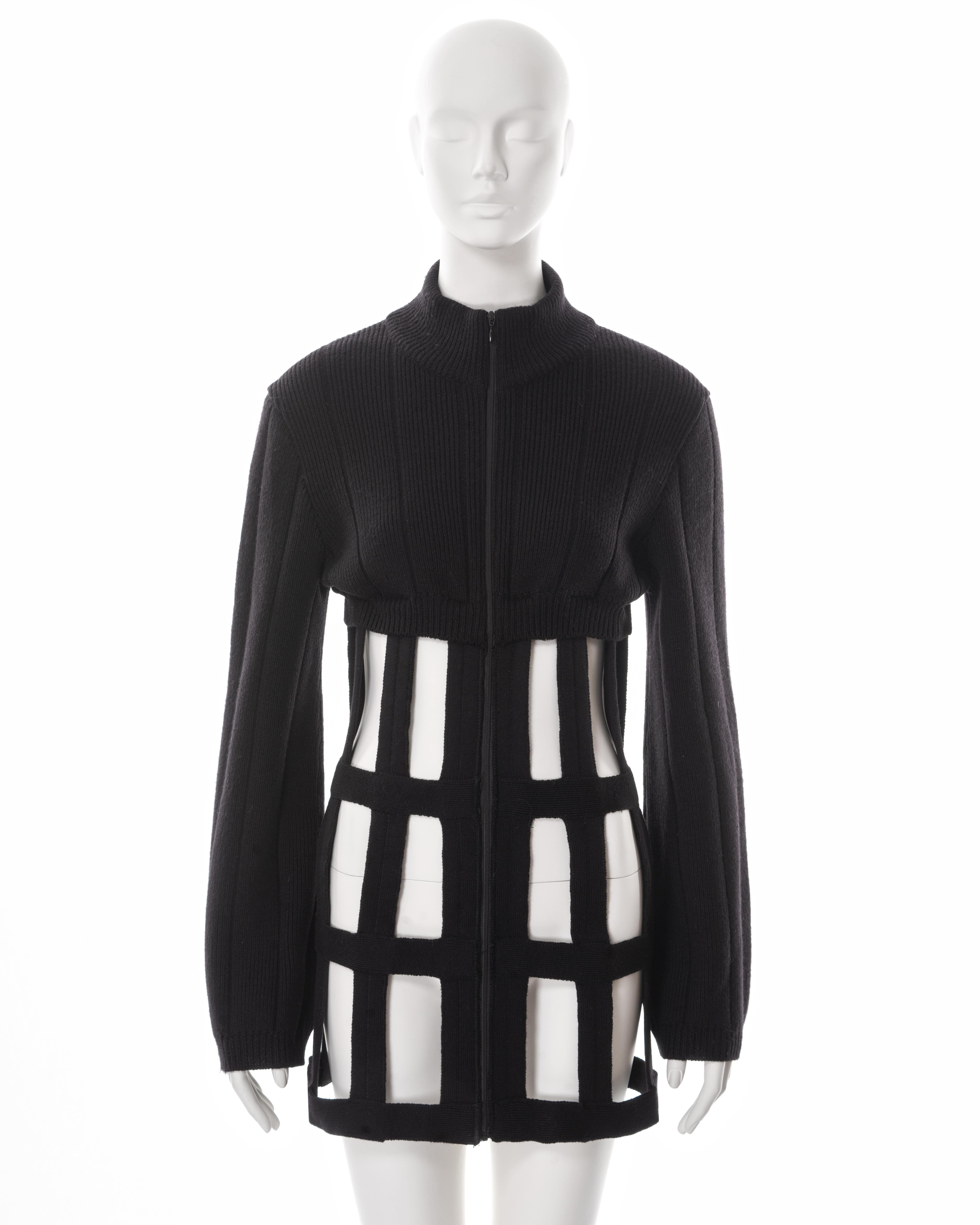 ▪ Jean Paul Gaultier sweater dress
▪ Sold by One of a Kind Archive
▪ Fall-Winter 1989
▪ Constructed from black ribbed-knit wool 
▪ Turtle neck 
▪ Caged skirt made up of a lattice of corset boning 
▪ Centre-front zipper 
▪ Long sleeves 
▪ IT 42 - FR