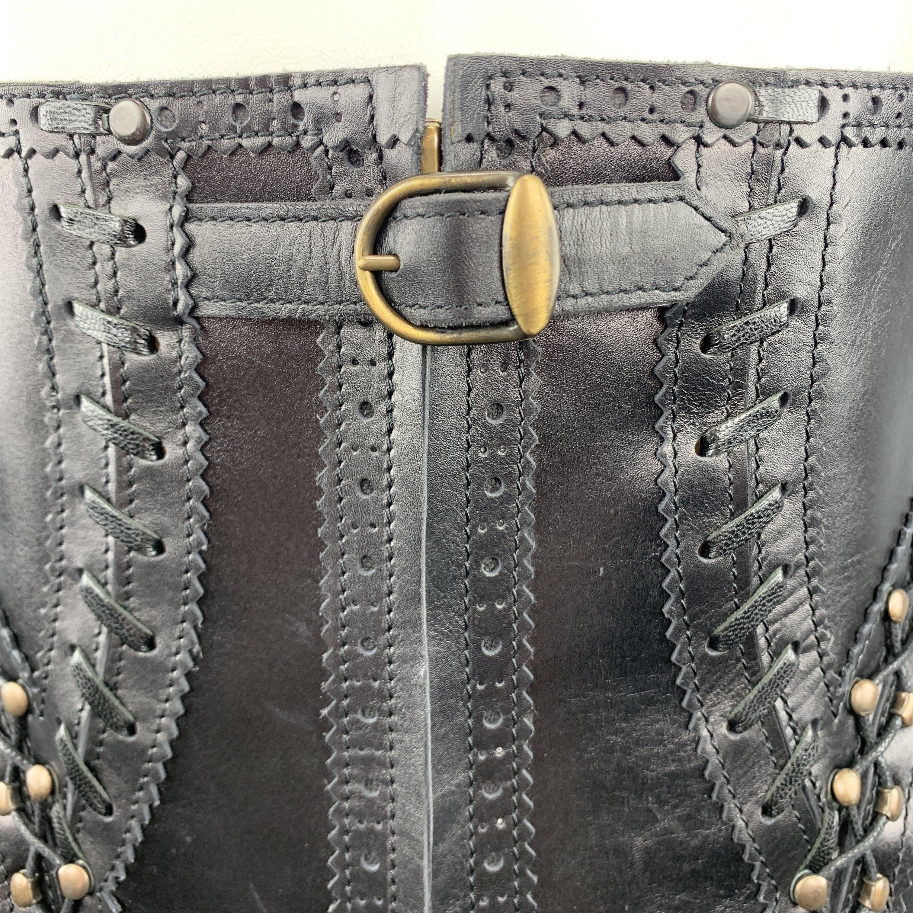 Vintage JEAN PAUL GAULTIER corset belt comes in black leather with a zip and buckle closure front, antique gold tone hardware, perforated brogue JPG sides, laced hook trim and adjustable lace up back. With dust bag.
 
Excellent Pre-Owned