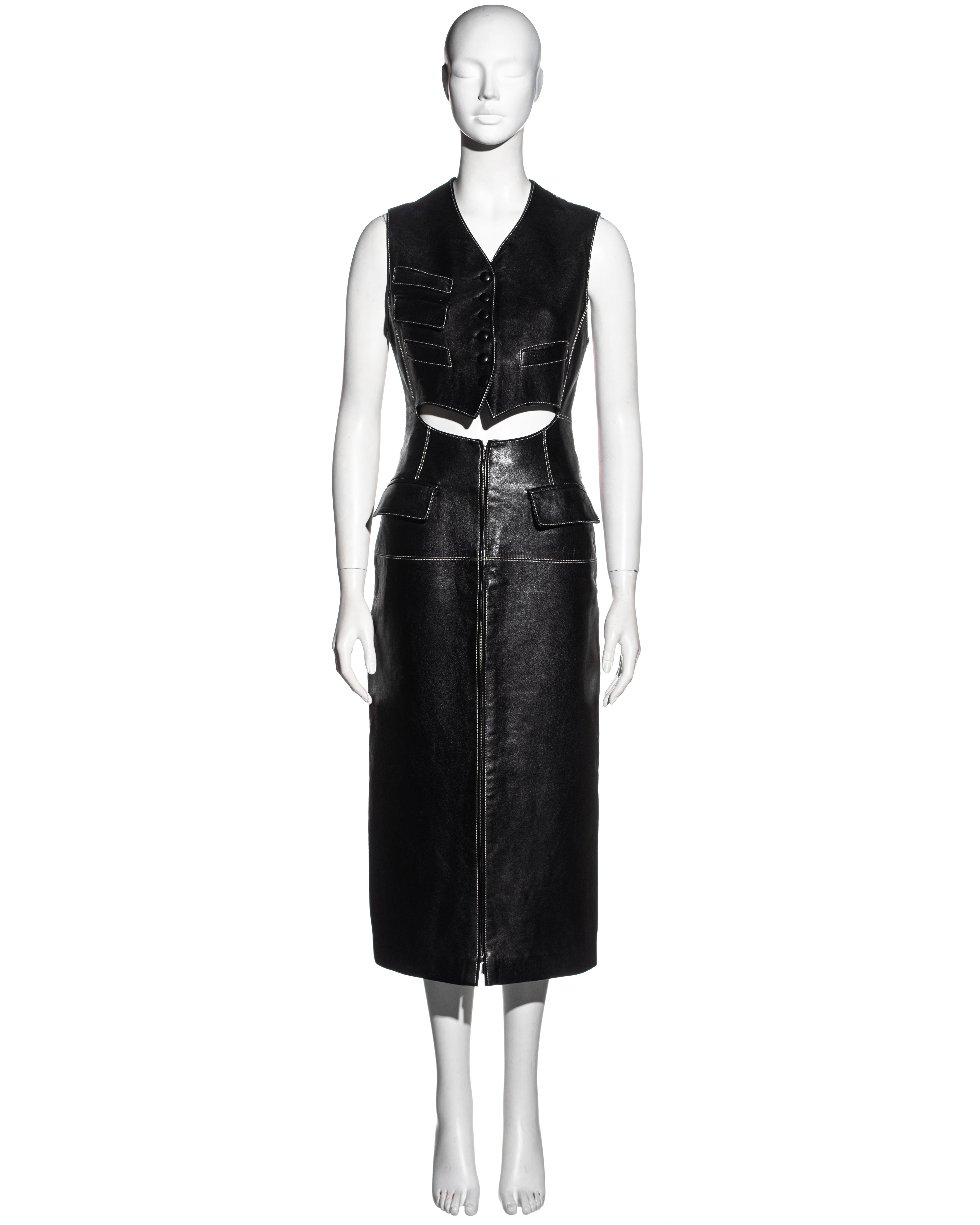▪ Jean Paul Gaultier black leather dress
▪ Waistcoat with striped cotton back and buckle fastening
▪ Bare midriff
▪ Leather covered buttons 
▪ Cream topstitch throughout 
▪ Attached calf-length pencil skirt with a metal zipper at the centre-front
▪