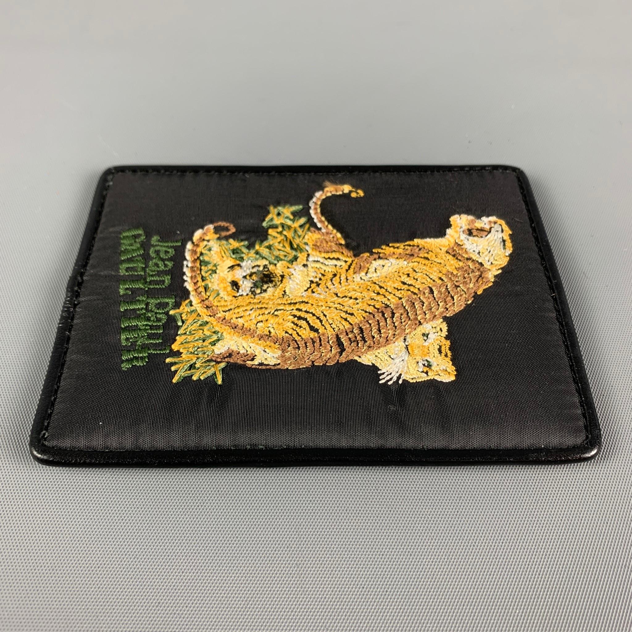 JEAN PAUL GAULTIER card holder comes in a black leather featuring a multi-color tiger embroidered design, double slots, and a clear sleeve. 

Good Pre-Owned Condition.

Measurements:

Length: 7.5 cm.
Height: 10 cm.