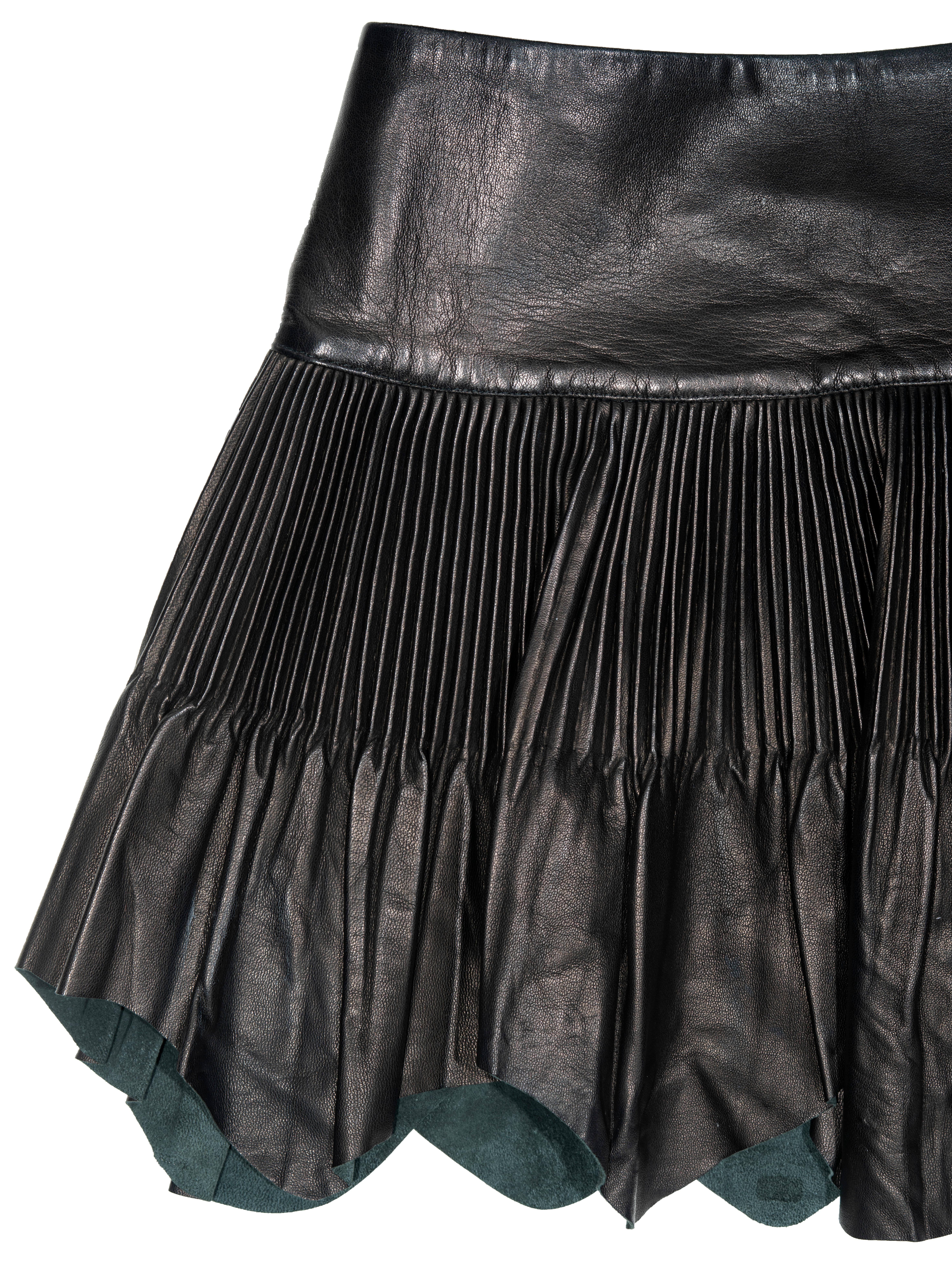 ▪ Jean Paul Gaultier mini wrap skirt
▪ Black finely pleated leather 
▪ Raw edge hem 
▪ Wrap fastening with long leather ties 
▪ IT 42 - FR 38 - UK 10
▪ Fall-Winter 2003
▪ 100% Leather
▪ Made in Italy