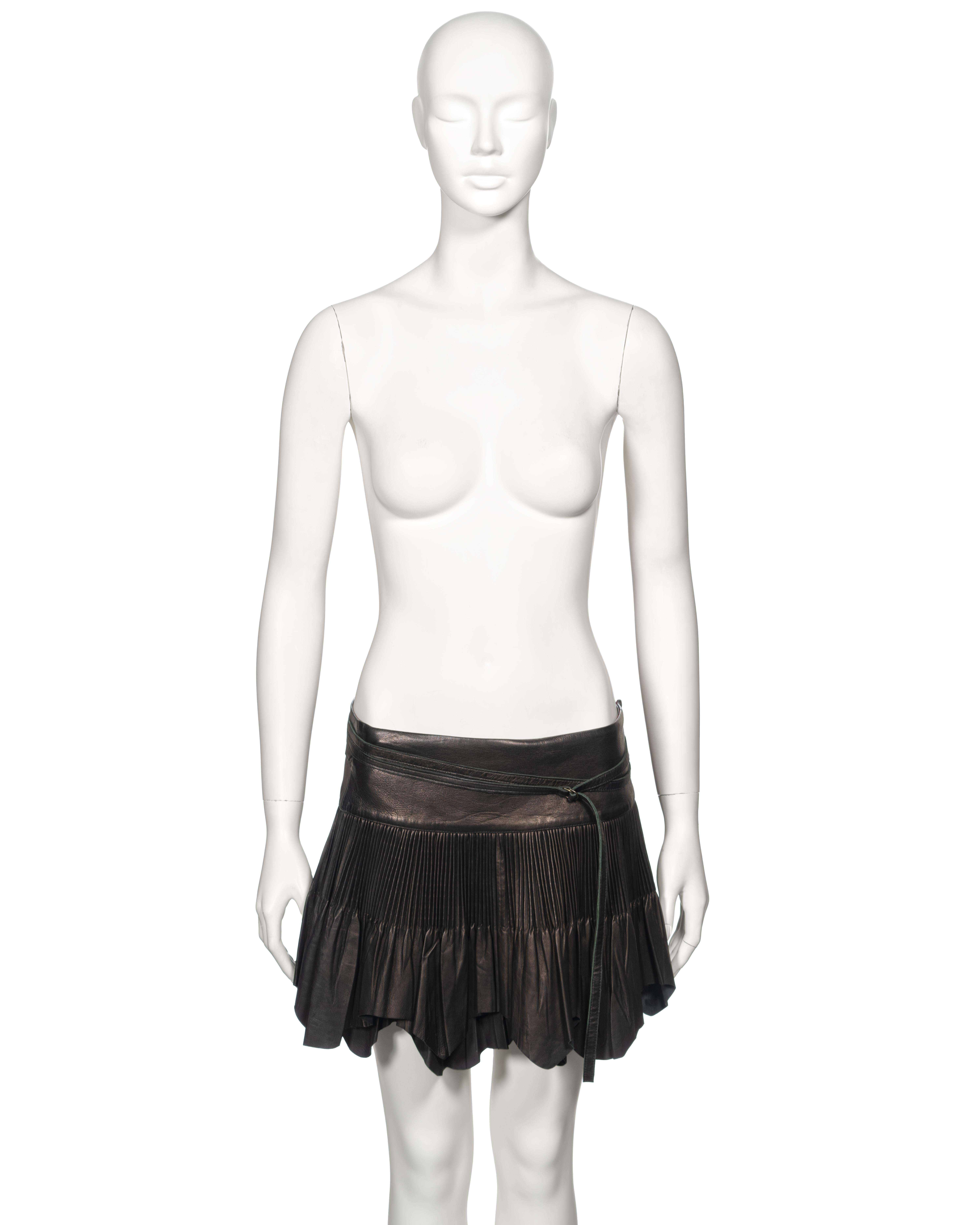 ▪ Archival Jean Paul Gaultier Leather Mini Skirt 
▪ Fall-Winter 2003
▪ Sold by One of a Kind Archive
▪ Constructed from black leather
▪ Cartridge pleats 
▪ Raw-edge hem 
▪ Self-tie wrap fastening
▪ IT42 - FR38 - UK10
▪ Made in Italy

The photographs
