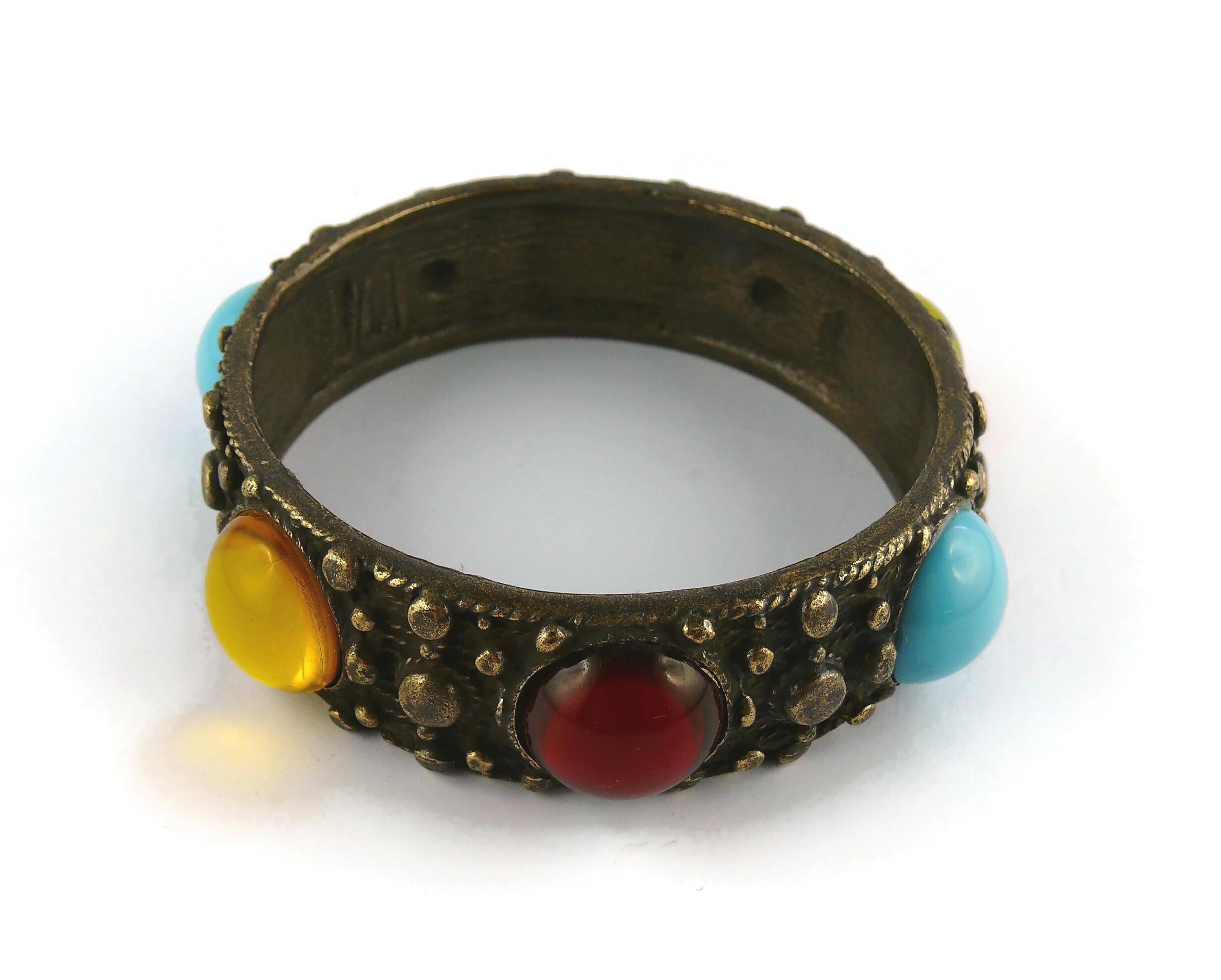 JEAN PAUL GAULTIER antiqued bronze toned bracelet embellished with multicolored glass cabochons.

Embossed JEAN PAUL GAULTIER.

Indicative measurements : inner circumference approx. 21.05 cm (8.29 inches) / total diameter approx. 7.4 cm (2.91