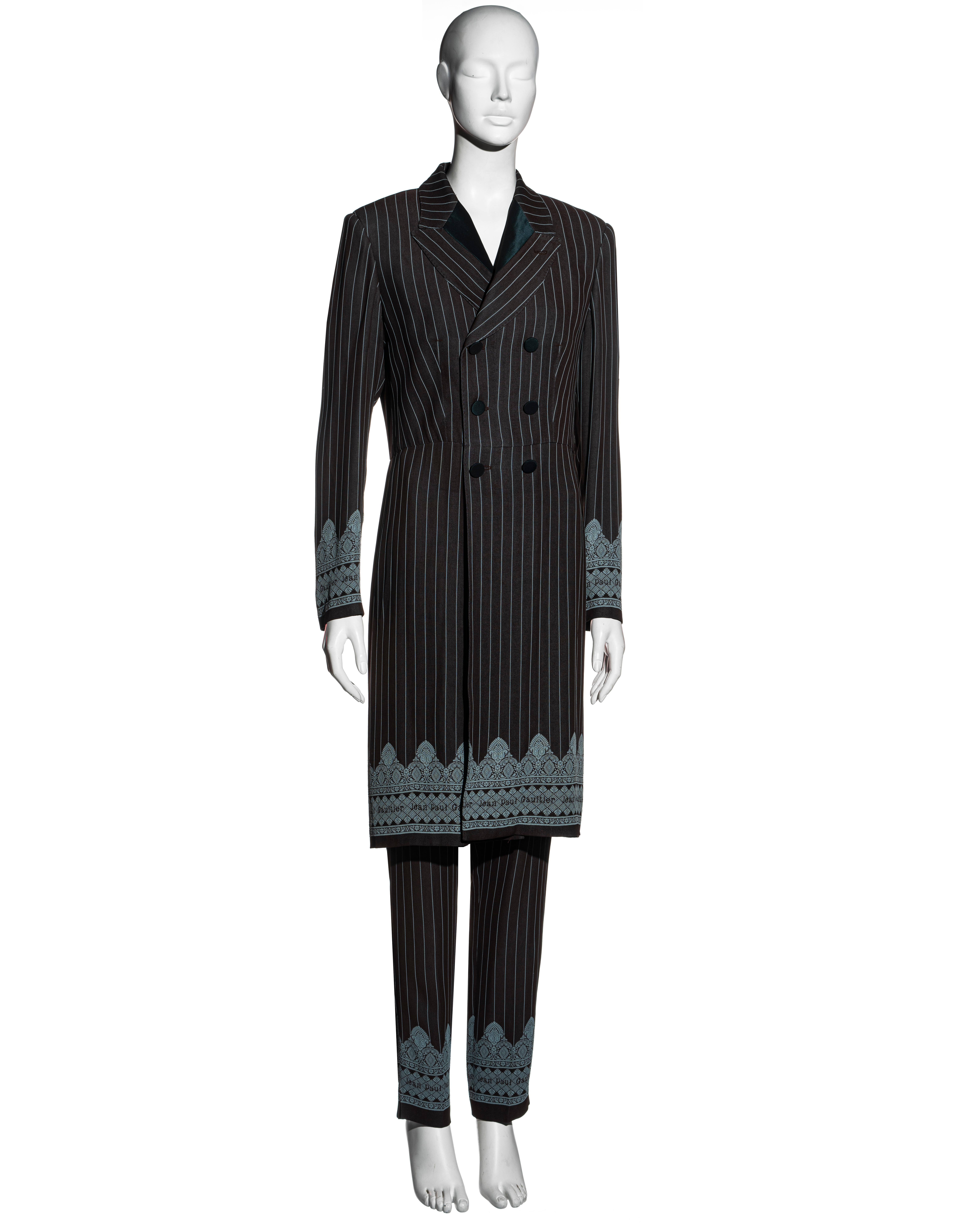 ▪ Jean Paul Gaultier brown and blue pinstripe pant suit
▪ Long double-breasted blazer jacket 
▪ Straight-leg pants 
▪ Black silk collar and buttons 
▪ Blue pattern at the cuffs and hemlines 
▪ IT 44 - FR 40 - UK 12
▪ Spring-Summer 1997
