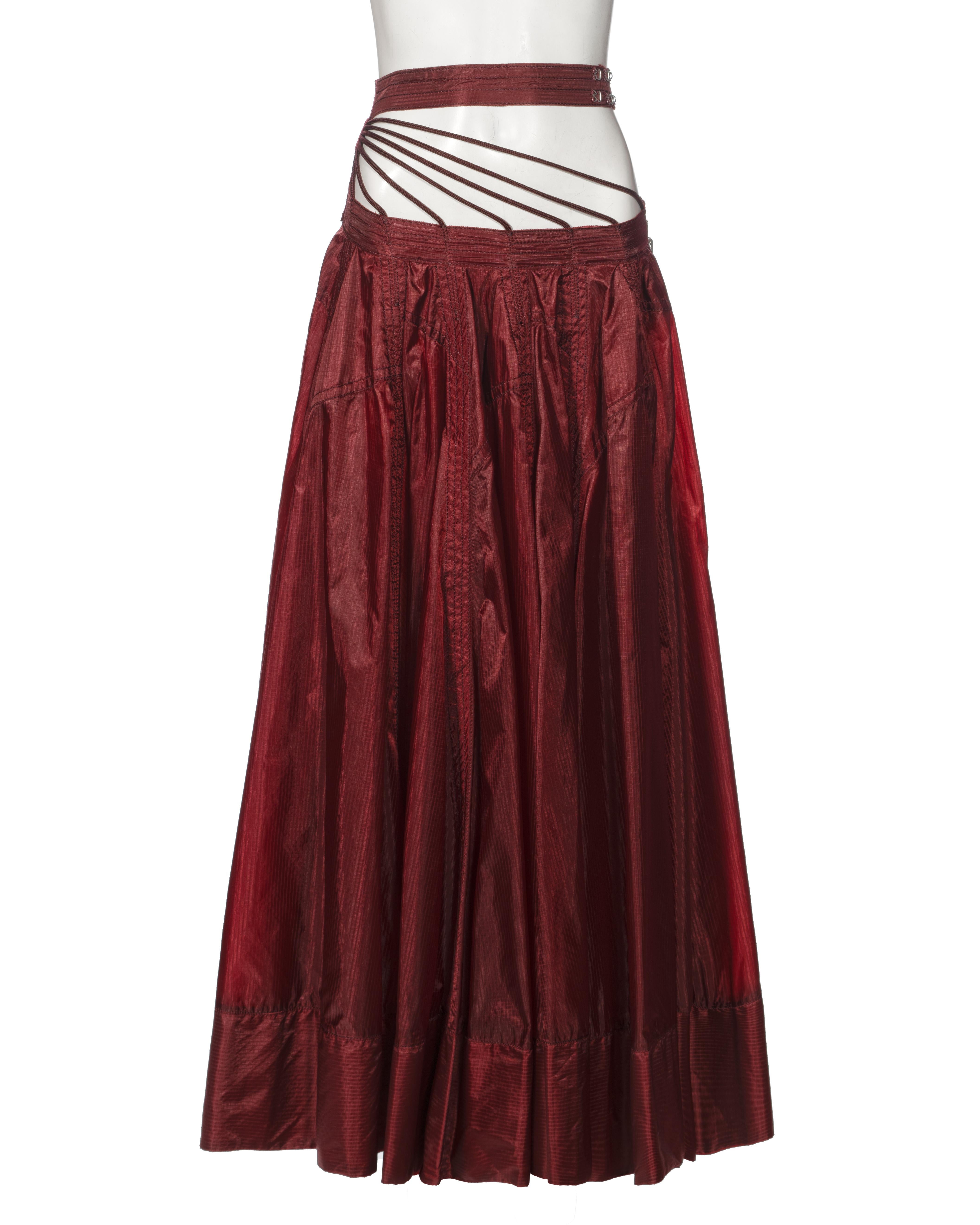 ▪ Archival Jean Paul Gaultier Skirt
▪ Spring-Summer 2002
▪ Sold by One of a Kind Archive
▪ Deep burgundy maxi skirt with a lustrous finish
▪ Strappy-waist detail linked to a separate waistband 
▪ Size zip closure 
▪ Material: Ripstop Nylon  
▪