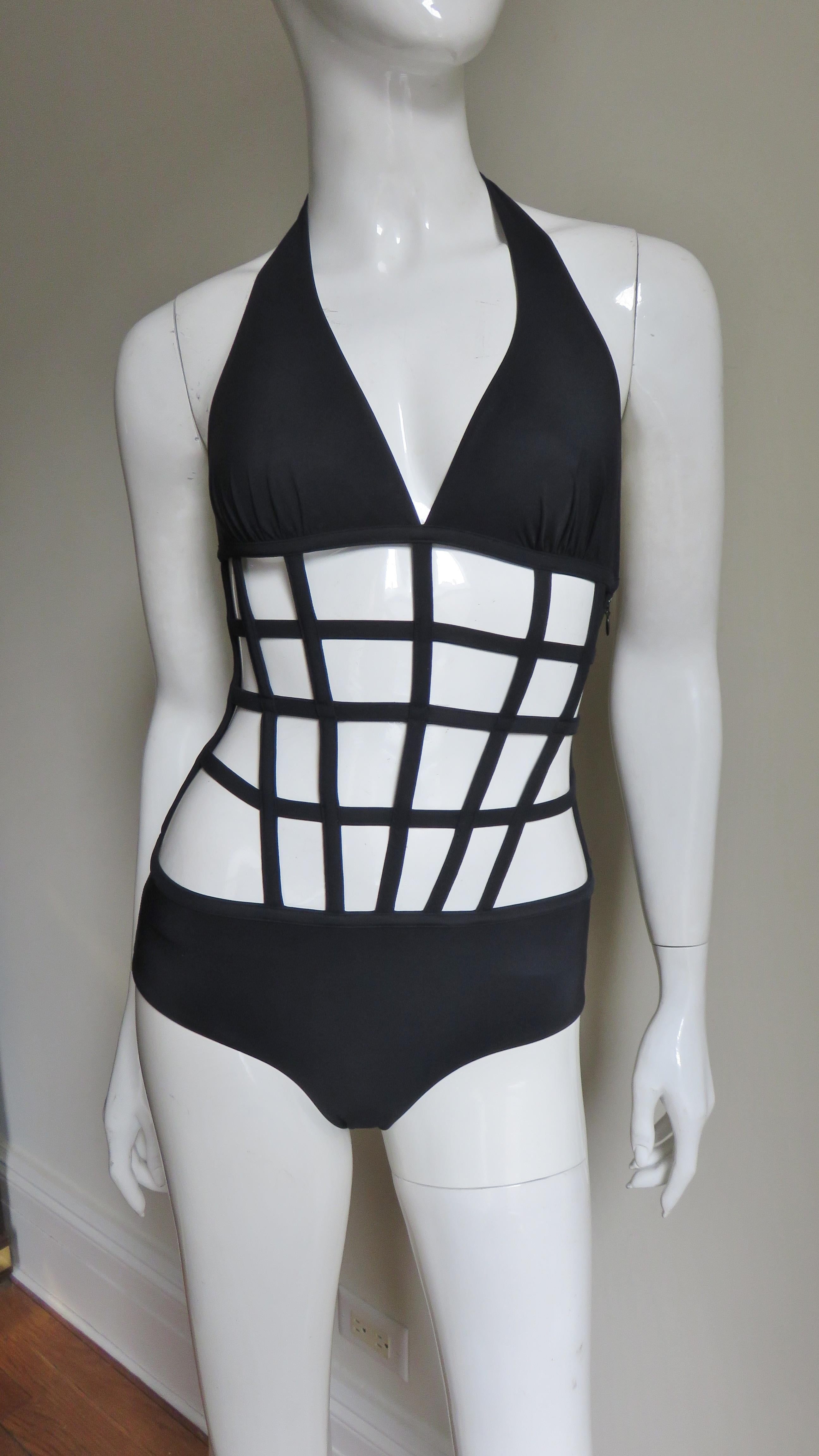 A great black swimsuit from Jean Paul Gaultier for La Perla. It has a halter style top and a bikini bottom joined together with boned strips both horizontal and vertical creating a geometric effect.  There is a side invisible zipper and a ties at