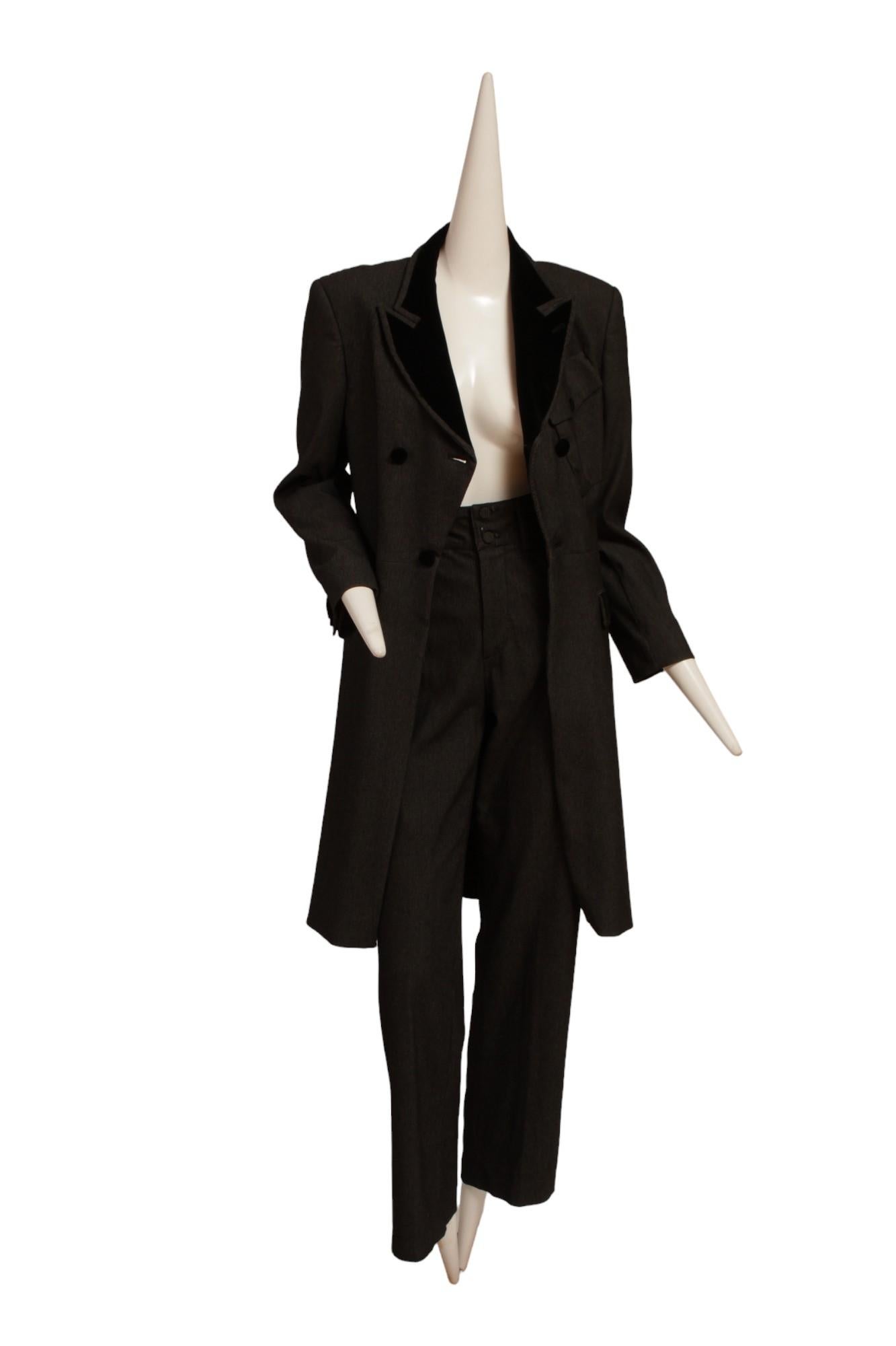 Jean Paul Gaultier Classique, smoking con pantaloni.
Questo smoking in misto lana e fibra artificiale è caratterizzato da una stampa a pois neri e da un tocco di velluto nero.  