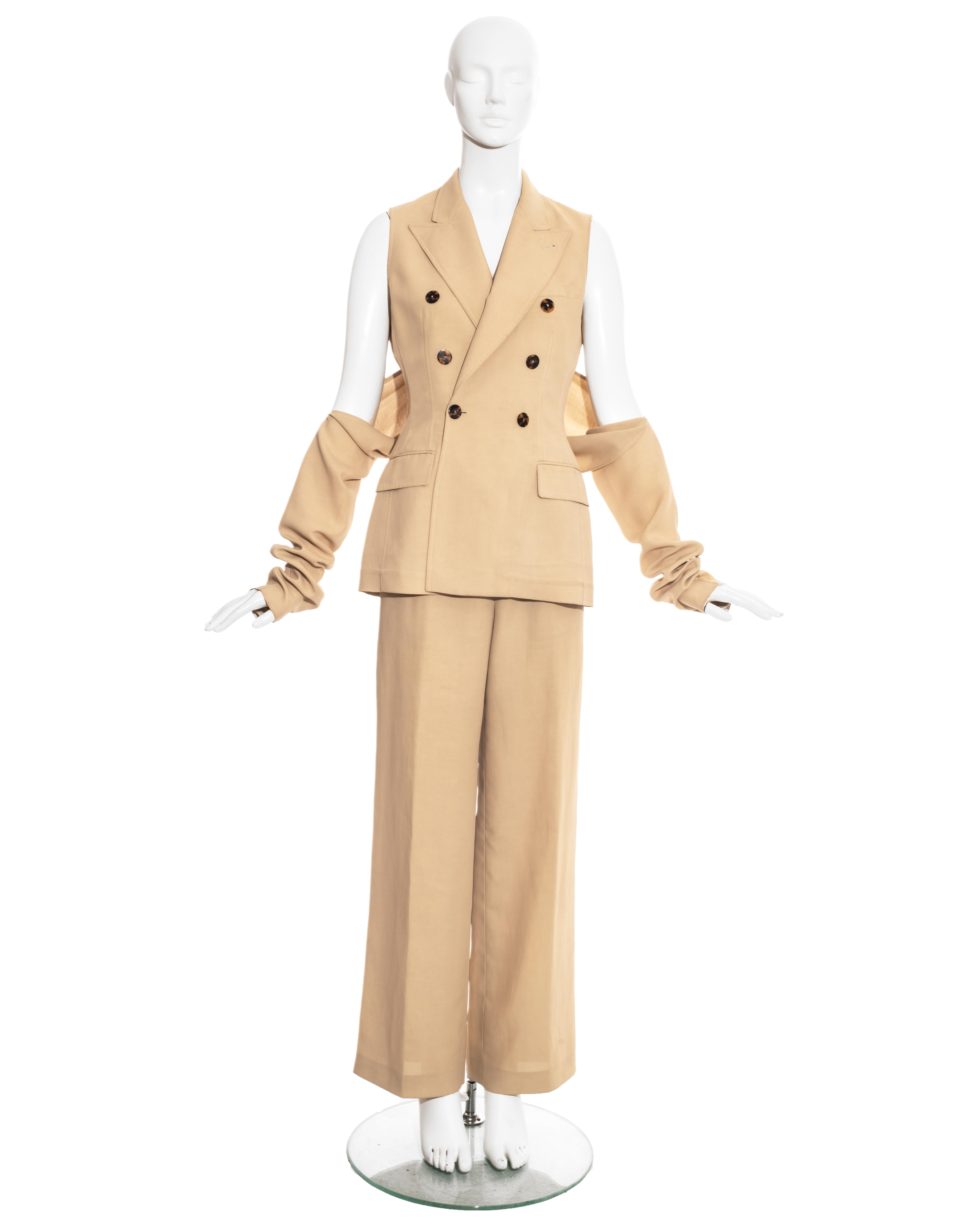 Jean Paul Gaultier cream linen three piece pant suit comprising: double breasted blazer jacket, bolero sleeve-jacket attaches with a button of the jacket, and wide leg pants.

Spring-Summer 1997