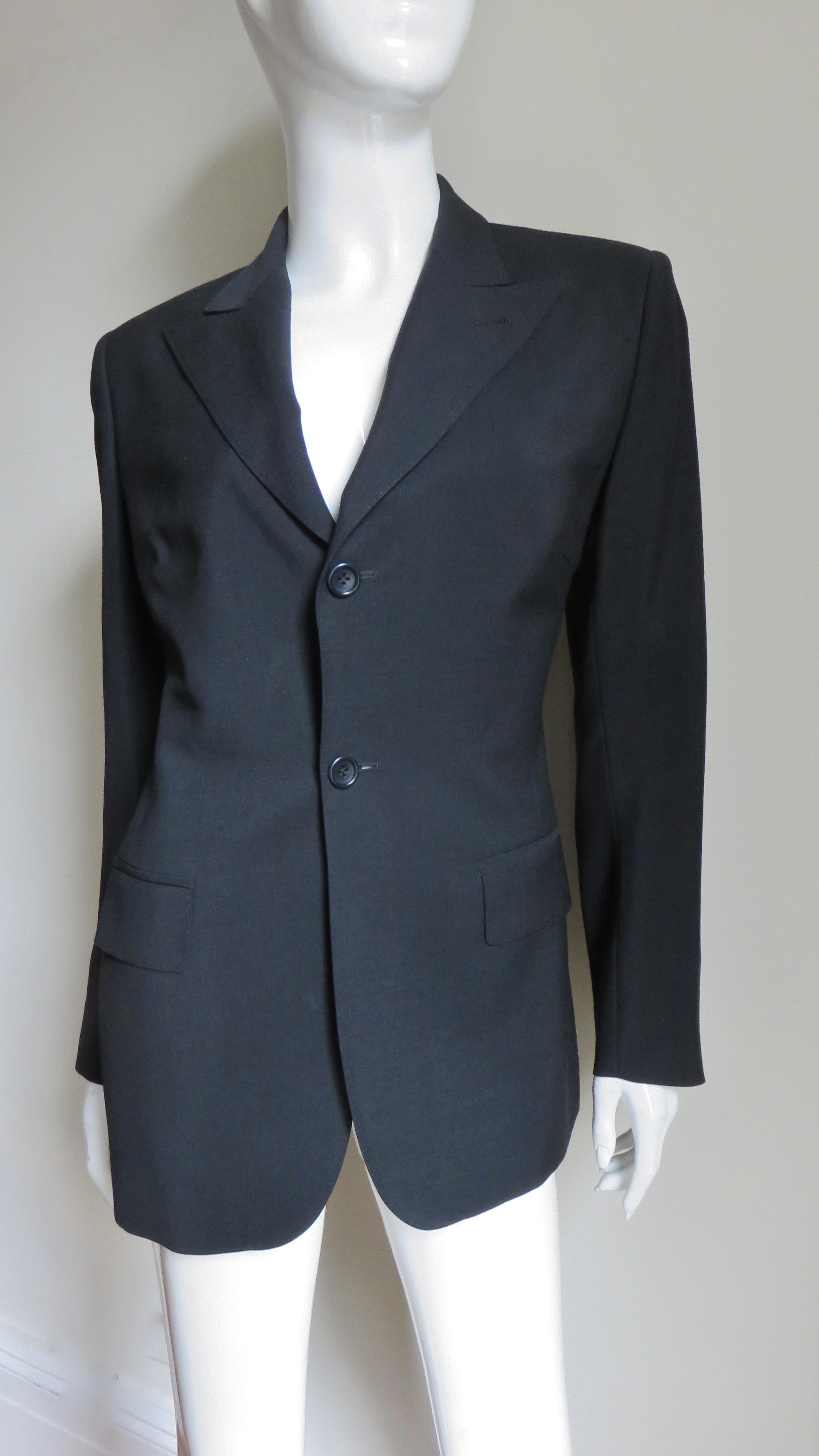 A fabulous black silk/wool blend jacket from Jean Paul Gaultier.  It is blazer with a button front, lapel collar, shoulder pads and front welt flap pockets.  The back is dramatic with a large square cut out from the shoulder blades to the waist.  It