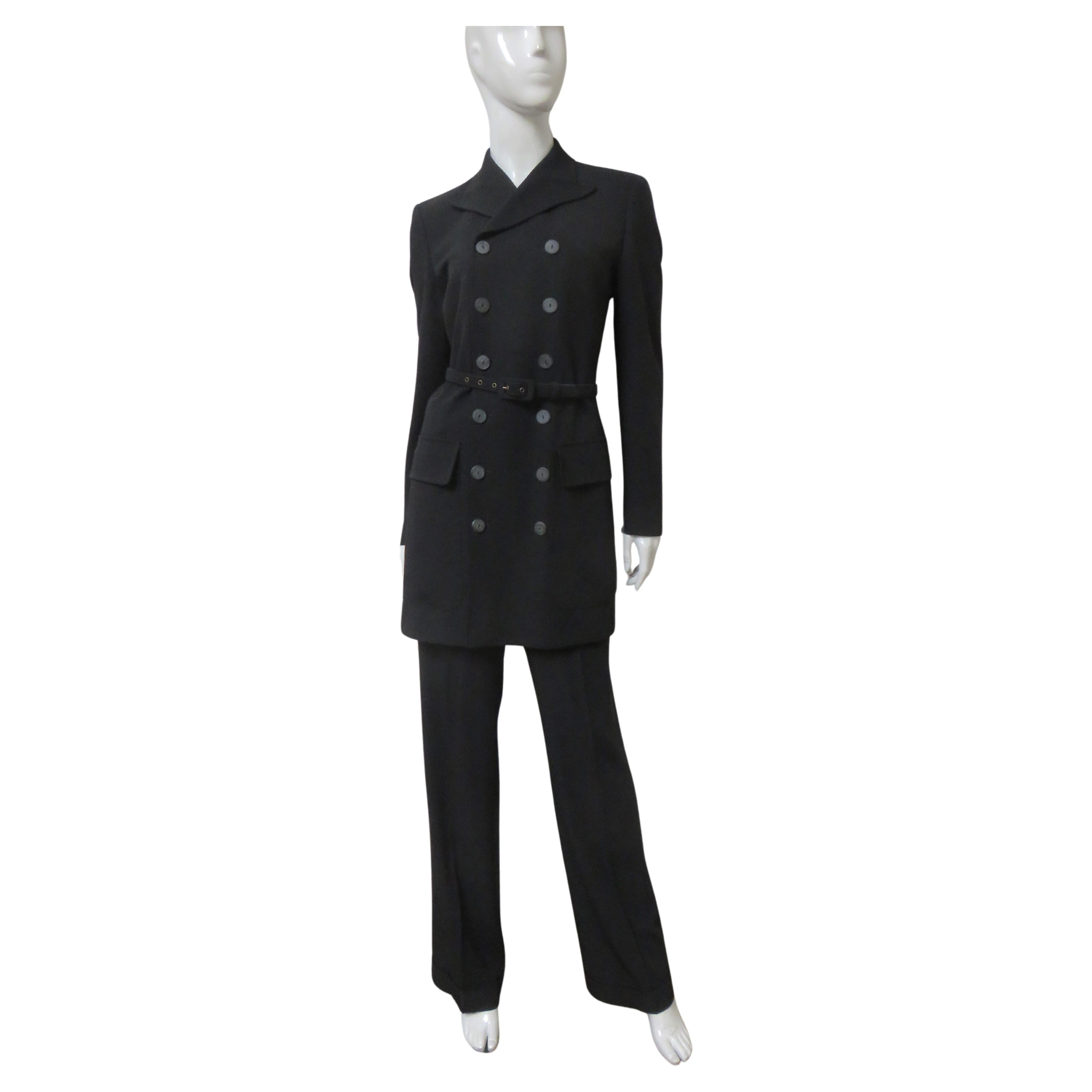 A fabulous black light weight wool with a bit of stretch pant suit from Jean Paul Gaultier.  It has an incredible long double breasted jacket with a lapel collar, flap pockets, buttons at the cuffs and a matching belt. The cuffed straight leg pants