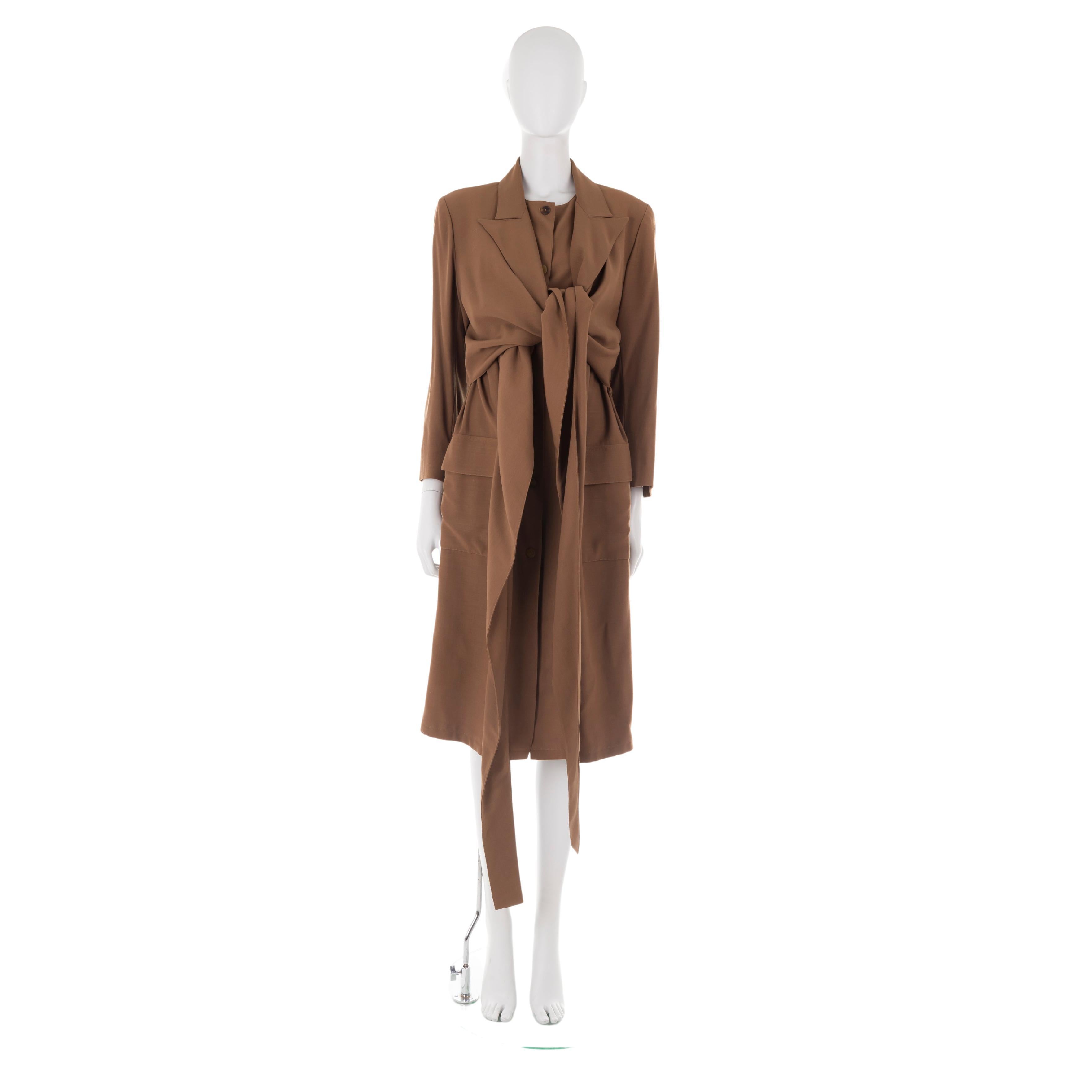 - Jean Paul Gaultier tobacco wool coat
- Sold by Gold Palms Vintage
- Fall/Winter 1983
- Produced by Gibo
- Double-structured trench coat with knotted overlay (adjustable at will)
- Button-up fastening underlay
- Two front maxi pockets
