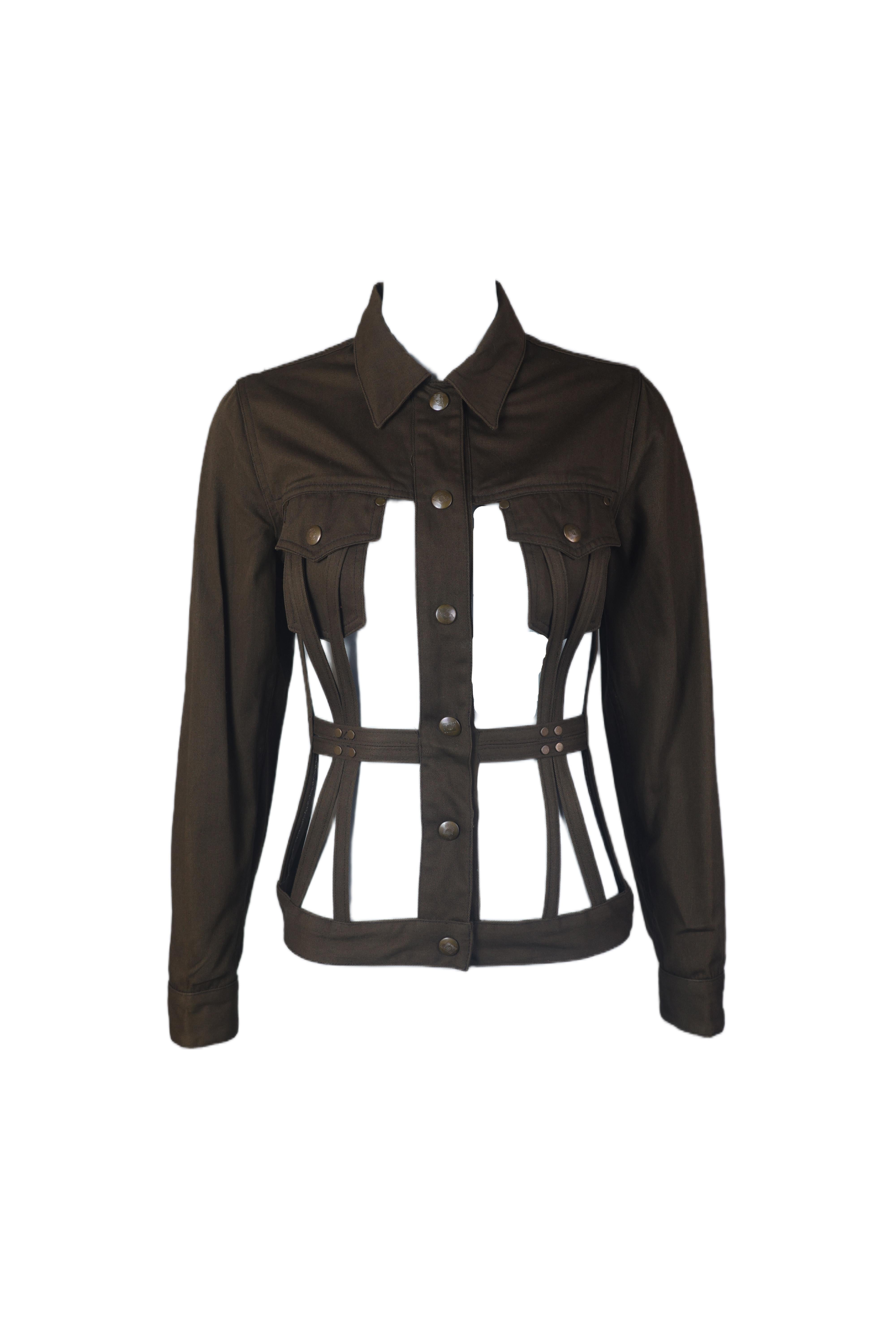 This unique jacket from Jean paul gaultier's late 1980s collection features a bold cutout design that creates a structured, cage-like effect. Made from durable fabric in a deep brown tone, it includes classic details such as a pointed collar,