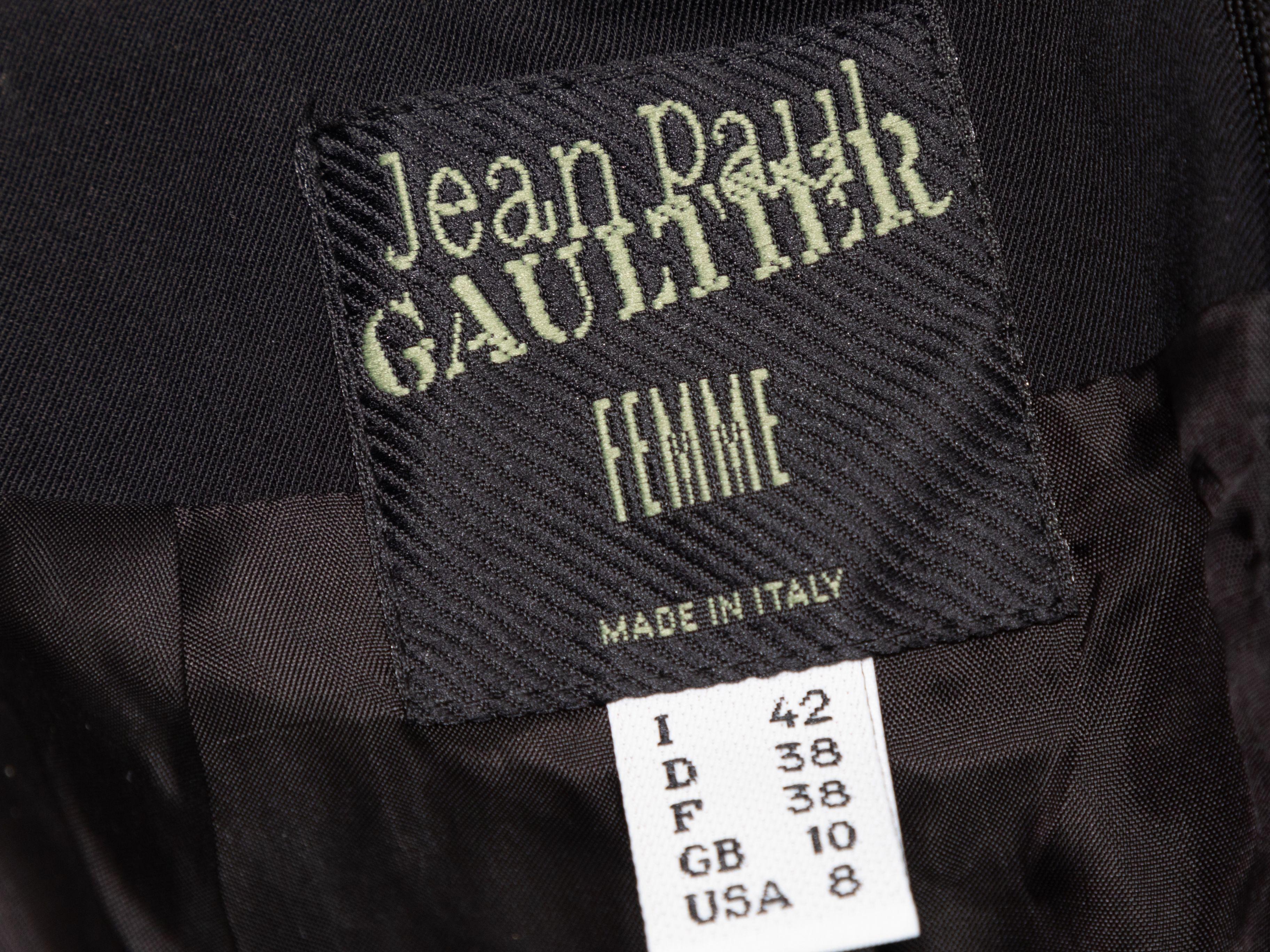 Product Details: Black wool knee-length skirt by Jean Paul Gaultier Femme. Gold-tone buckle strap accent at back. Zip closure at center back. 28