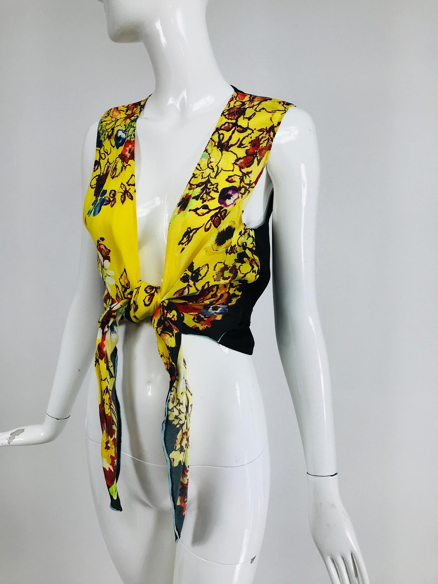Jean Paul Gaultier Femme, tie front floral plunge V neckline top with a black vest back with a bow tie at the waist. The front ties can be tied high and tight or loose and lower. The front is unlined crepe in yellow with colourful fantasy flowers.