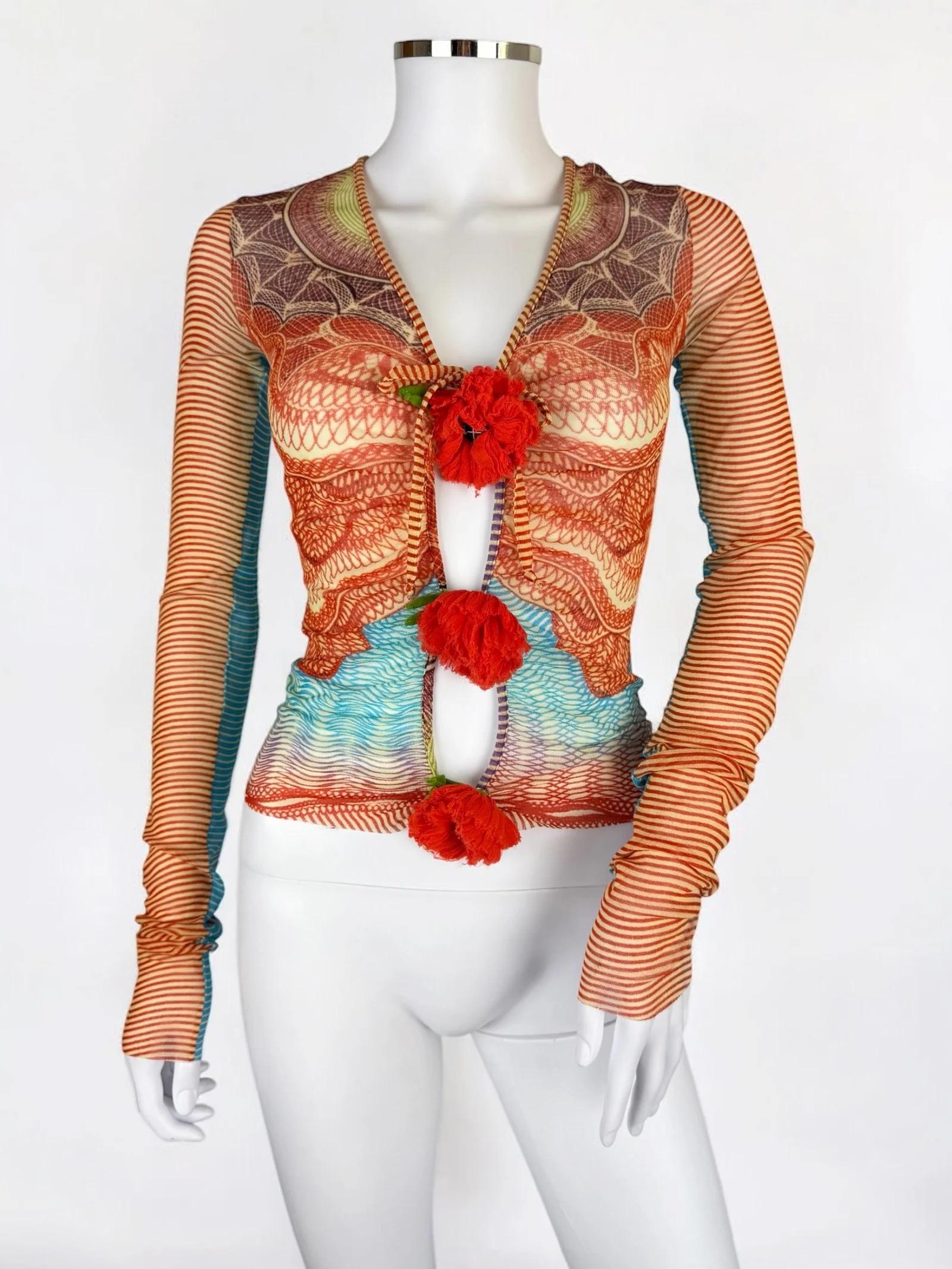 
Jean Paul Gaultier Oberteil mit langen Ärmeln aus durchsichtigem Netz, 1990er Jahre
Kompliziertes kaleidoskopisches Muster in warmen Rot- und Orangetönen mit kühlen Blau- und Grüntönen.
Das Design der Vorderseite ist besonders dramatisch - das