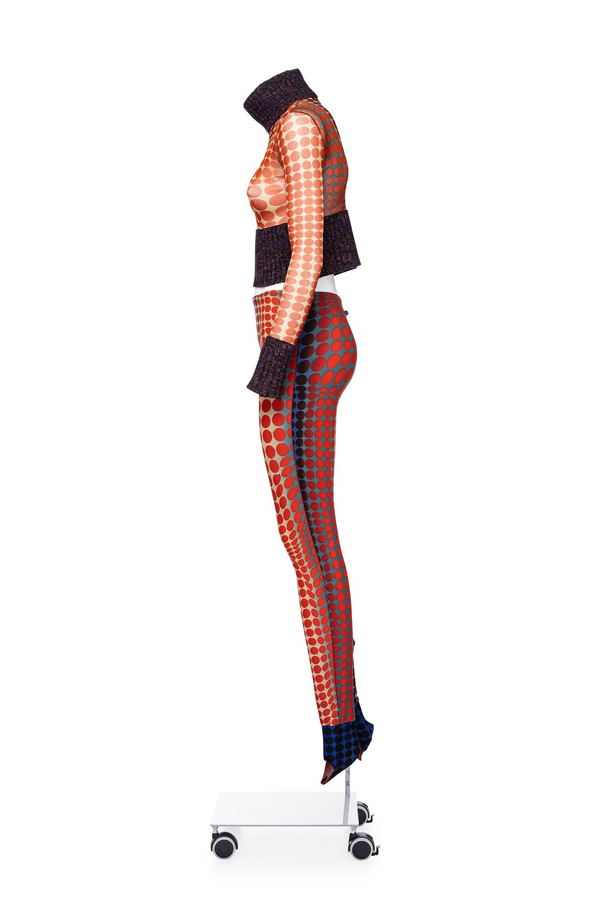 Conjunto icónico y poco común de ciberpuntos de la colección 'Cavalières et Amazones des Temp Modernes' de Jean Paul Gaultier, otoño-invierno de 1995.
Top de malla transparente con cuello y mangas de punto.
Leggings con tacones anatómicos.
Gorra a
