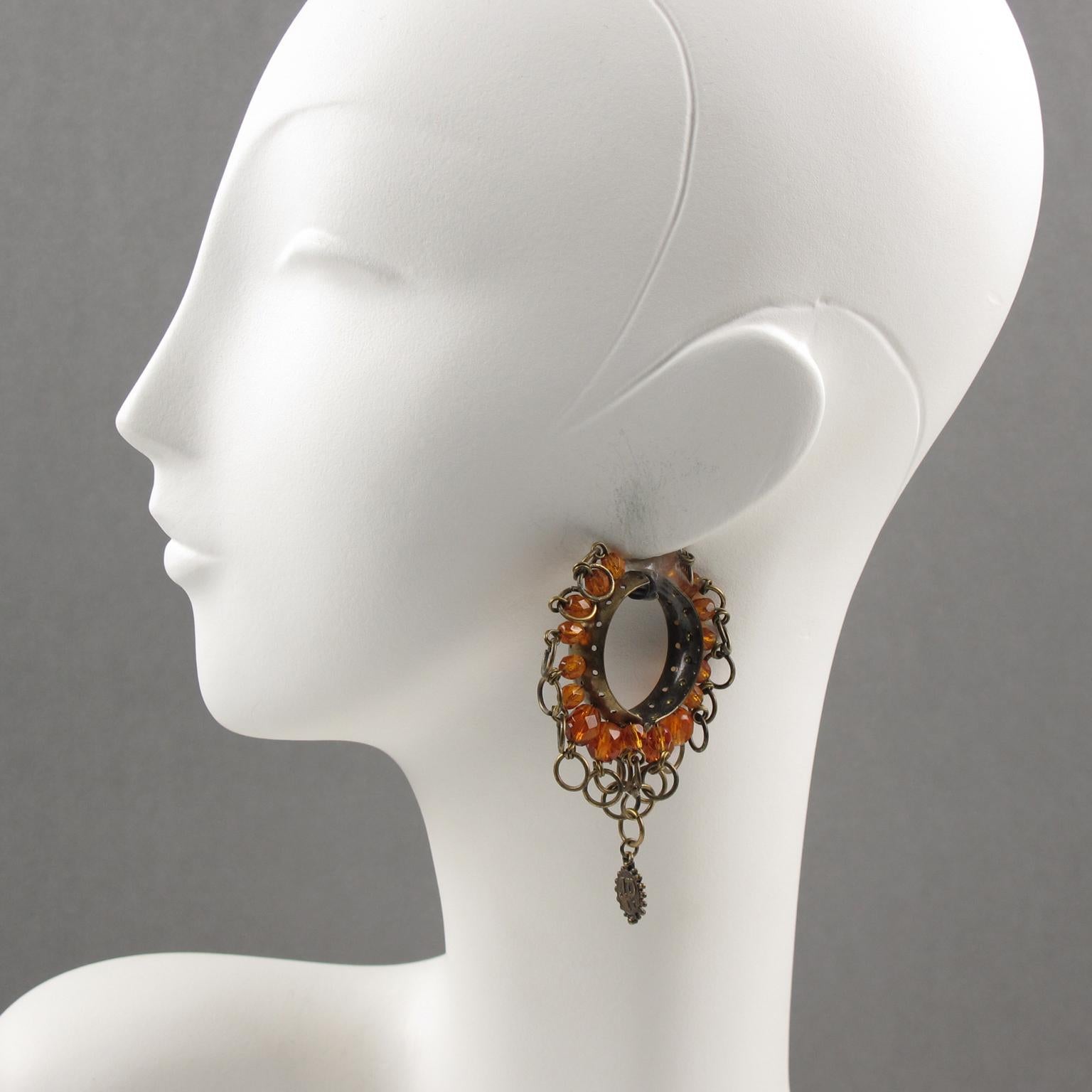 Lovely Jean Paul Gaultier Paris gothic inspiration signed clip-on earrings. Large hoop shape in gilt metal with aged patina ornate with metal rings and orange glass faceted beads. Dangling 
