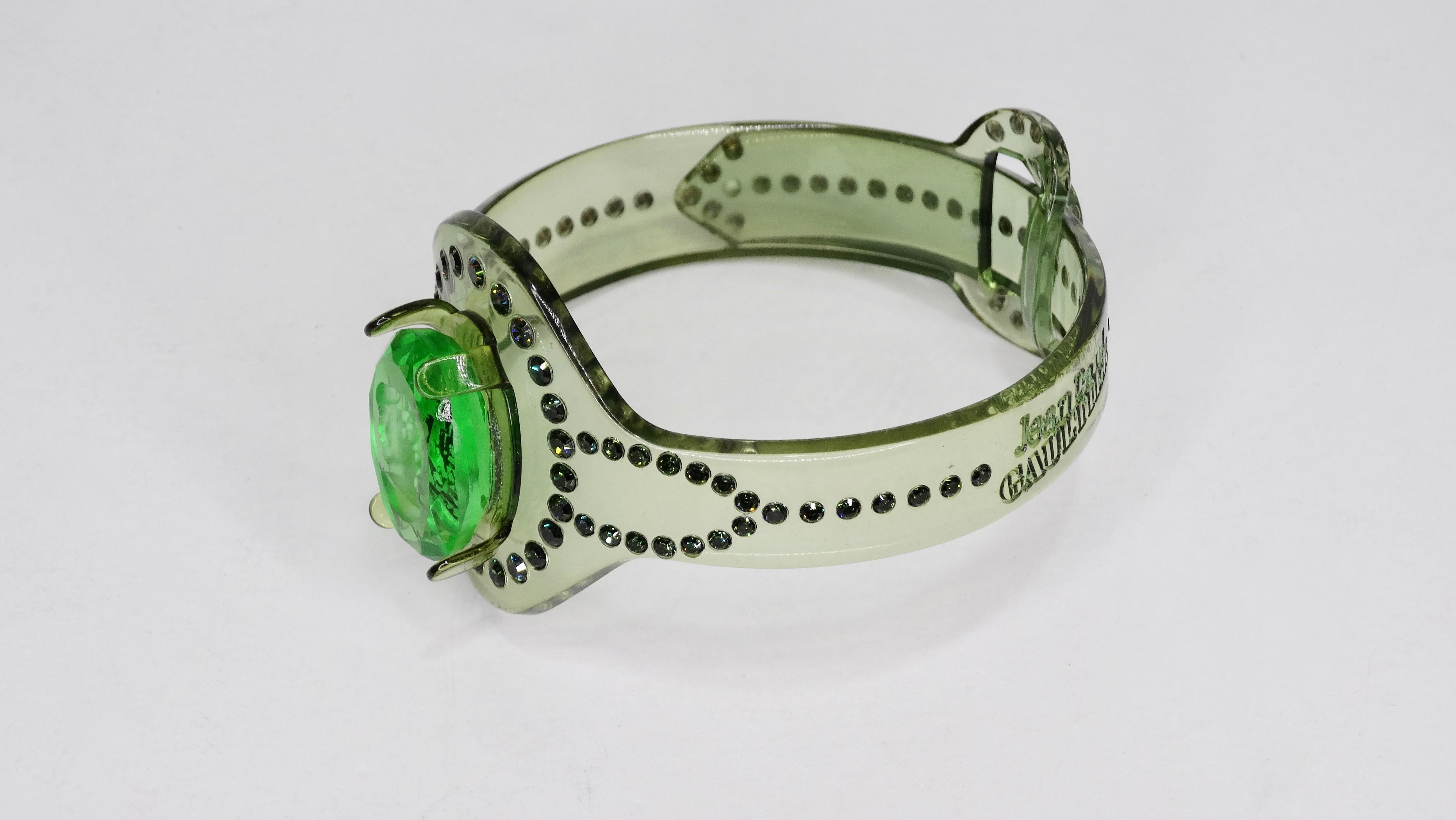 Add some edge to your looks! Circa early 2000s, this green acrylic bracelet is adorned with rhinestones and a lime green intaglio motif. Stamped JPG and opens like a belt closure. Best fit for a size 7-9