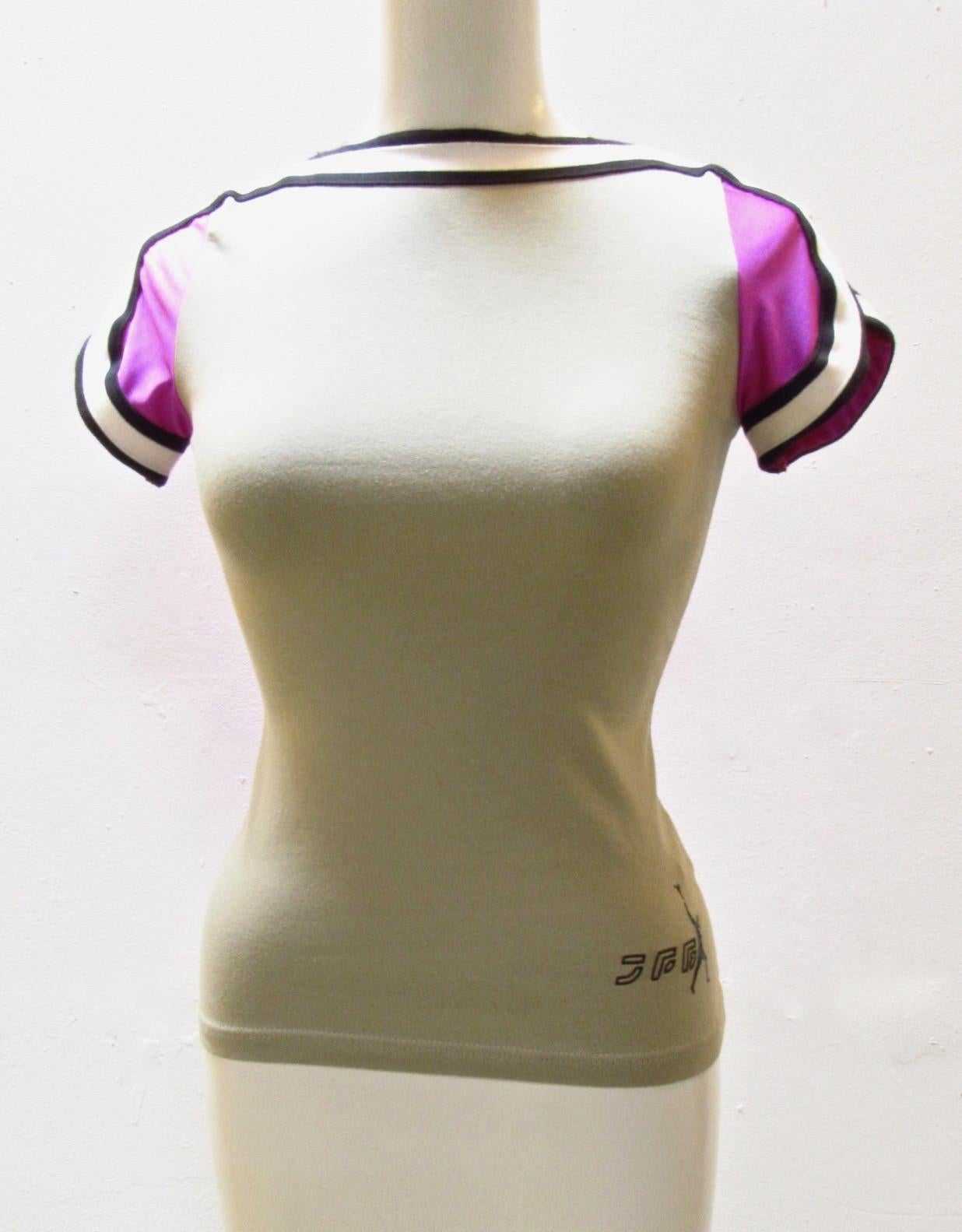 This fitted tee from vintage Jean Paul Gaultier Sport is a subtle grey in front and vibrant purple in back and features contrasting black and white collar and cuffs. The JPG Sport logo appears on the bottom left side. 
