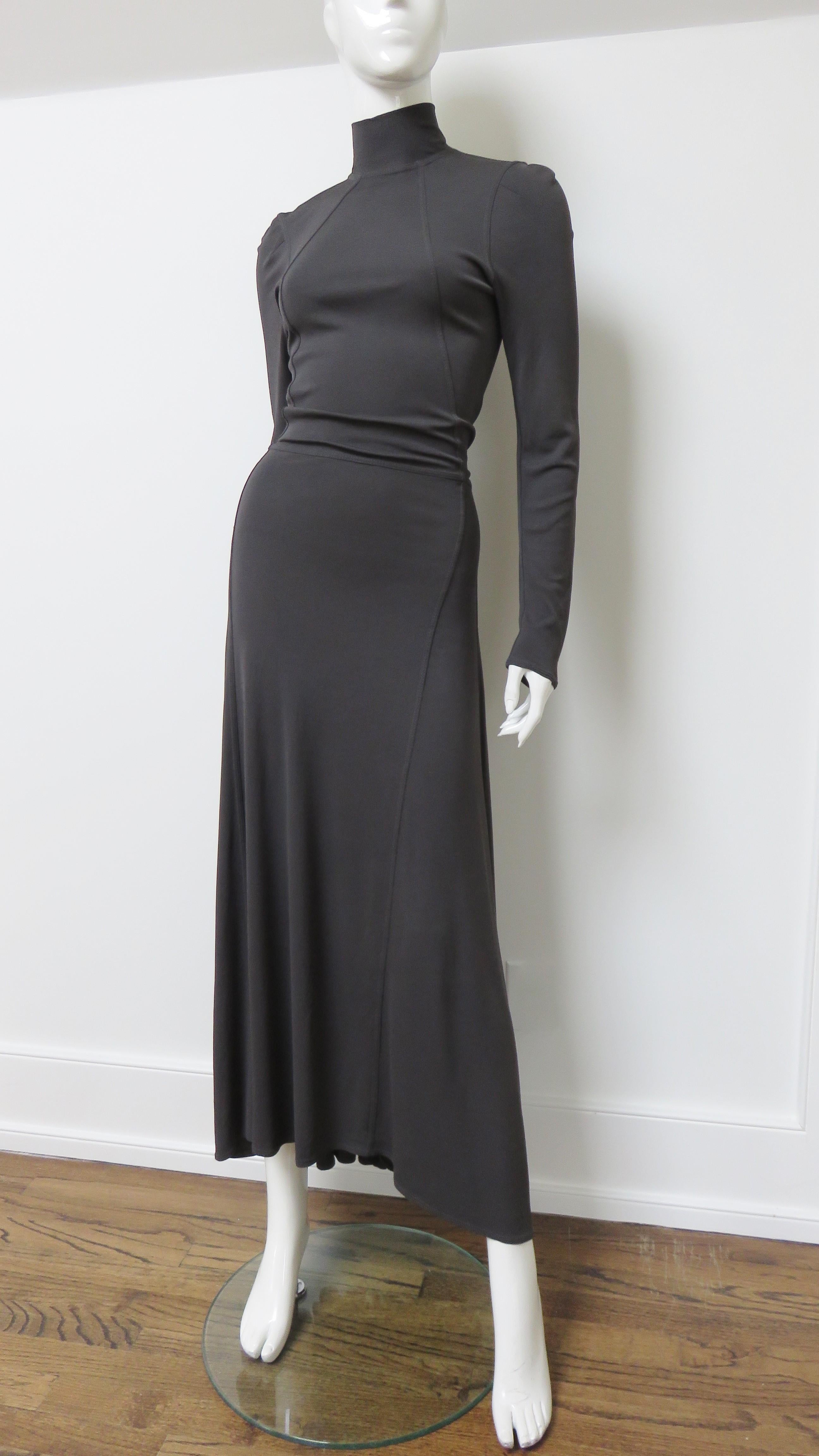 A fabulous fitted charcoal grey jersey dress from Jean Paul Gaultier.  It has a stand up collar and is fitted through to the waist with angled seaming.  The skirt flares to the hem and is longer in the back.  A large silver zipper with a long