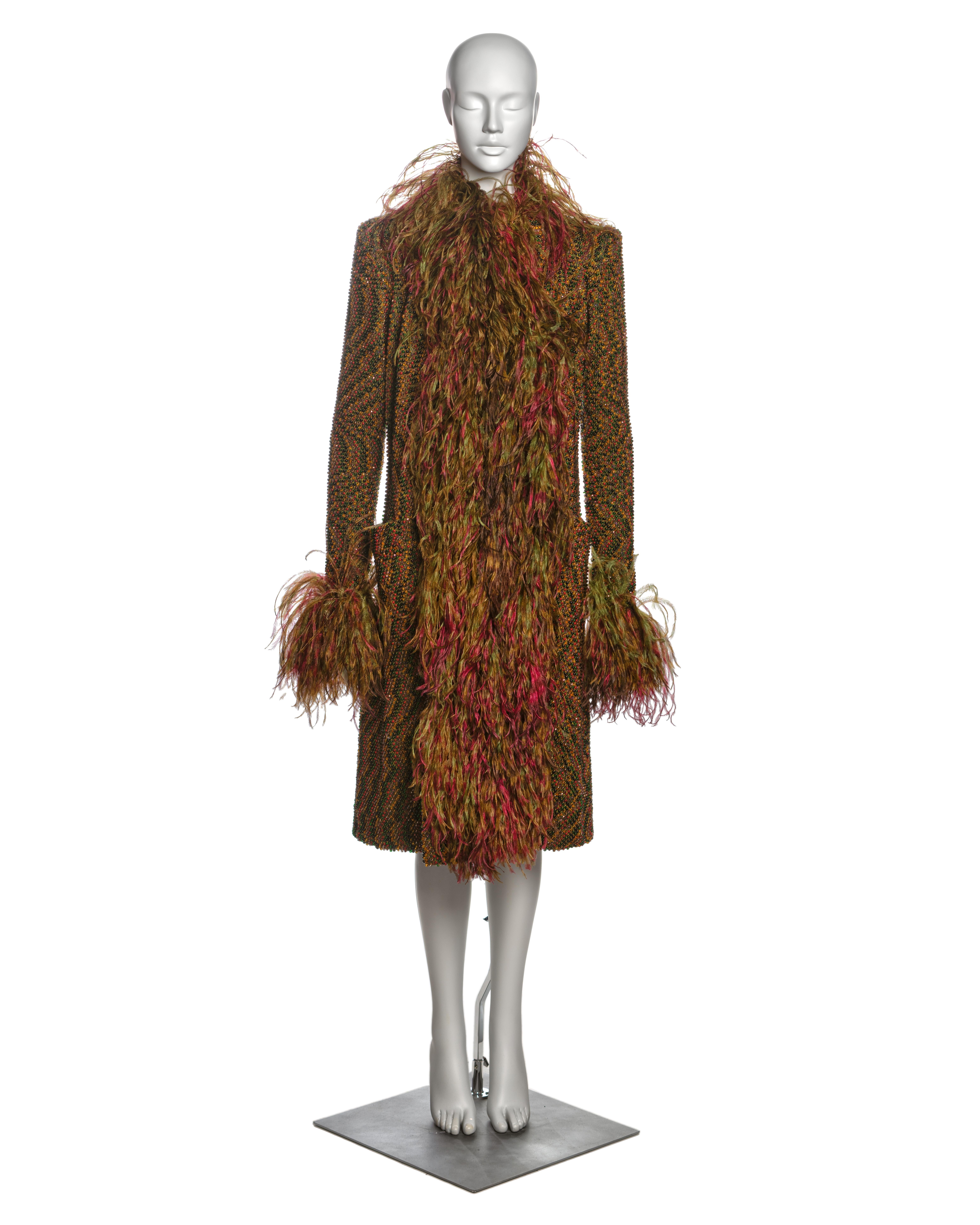Jean Paul Gaultier Haute Couture evening coat meticulously hand-beaded on knitted wool to resemble tweed. It features a straight, knee-length cut, with a collar and cuffs adorned with ostrich feathers in olive and magenta tones. Fully lined in silk,
