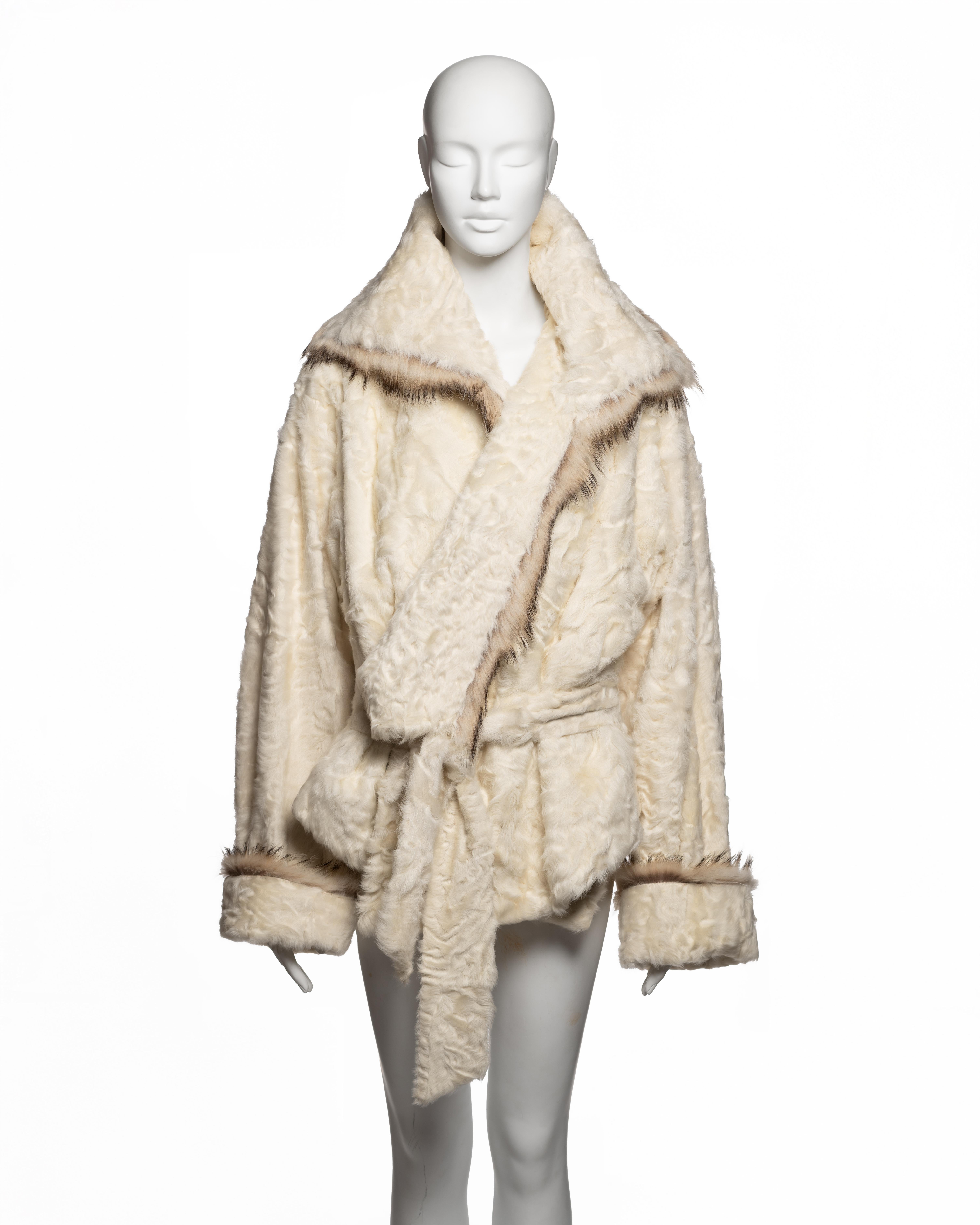 Jean Paul Gaultier wrap jacket from the Fall-Winter 2005 collection, constructed in ivory astrakhan with a tonal acetate lining and trimmed with natural Persian lamb at the collar and cuffs. The silhouette is oversized and softly structured,
