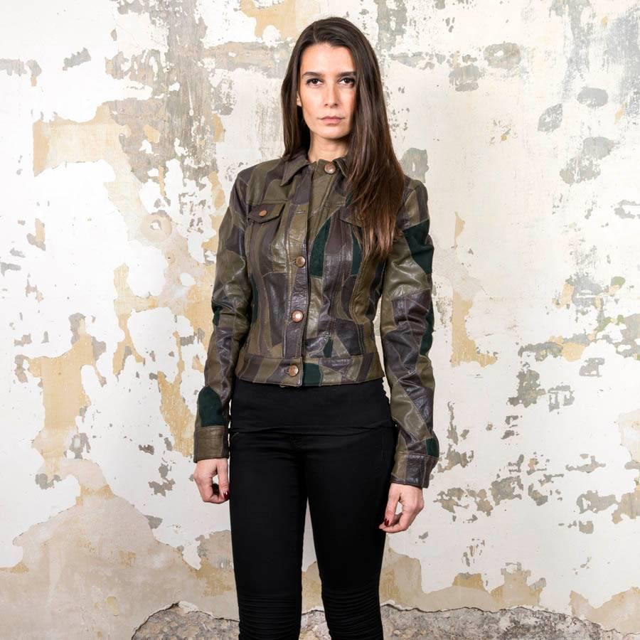 Jean Paul Gaultier jacket in patchwork of green and brown leather and calf velvet. It is lined with a satin green khaki interior. It closes with a row of oxidized steel effect buttons with a lapel on each side of the chest, buttoned button effect.