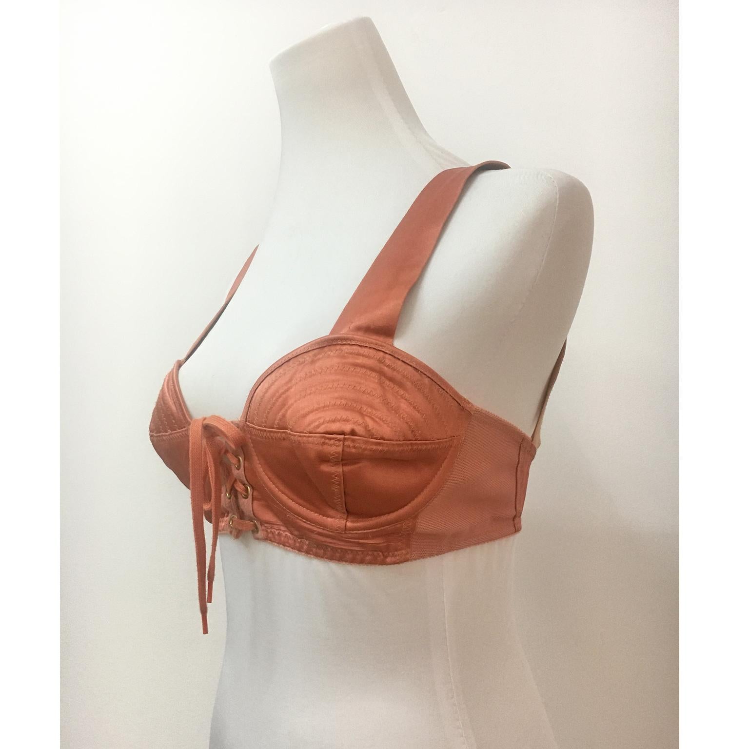Iconic Jean Paul Gaultier bustier JPG junior line in satin peach colour from circa 80s. It features sculptured bra cups and adjustable laces up with gold tone eyelets in the front, elastic straps.
Size : FR 42 ( 36-38 EU) 