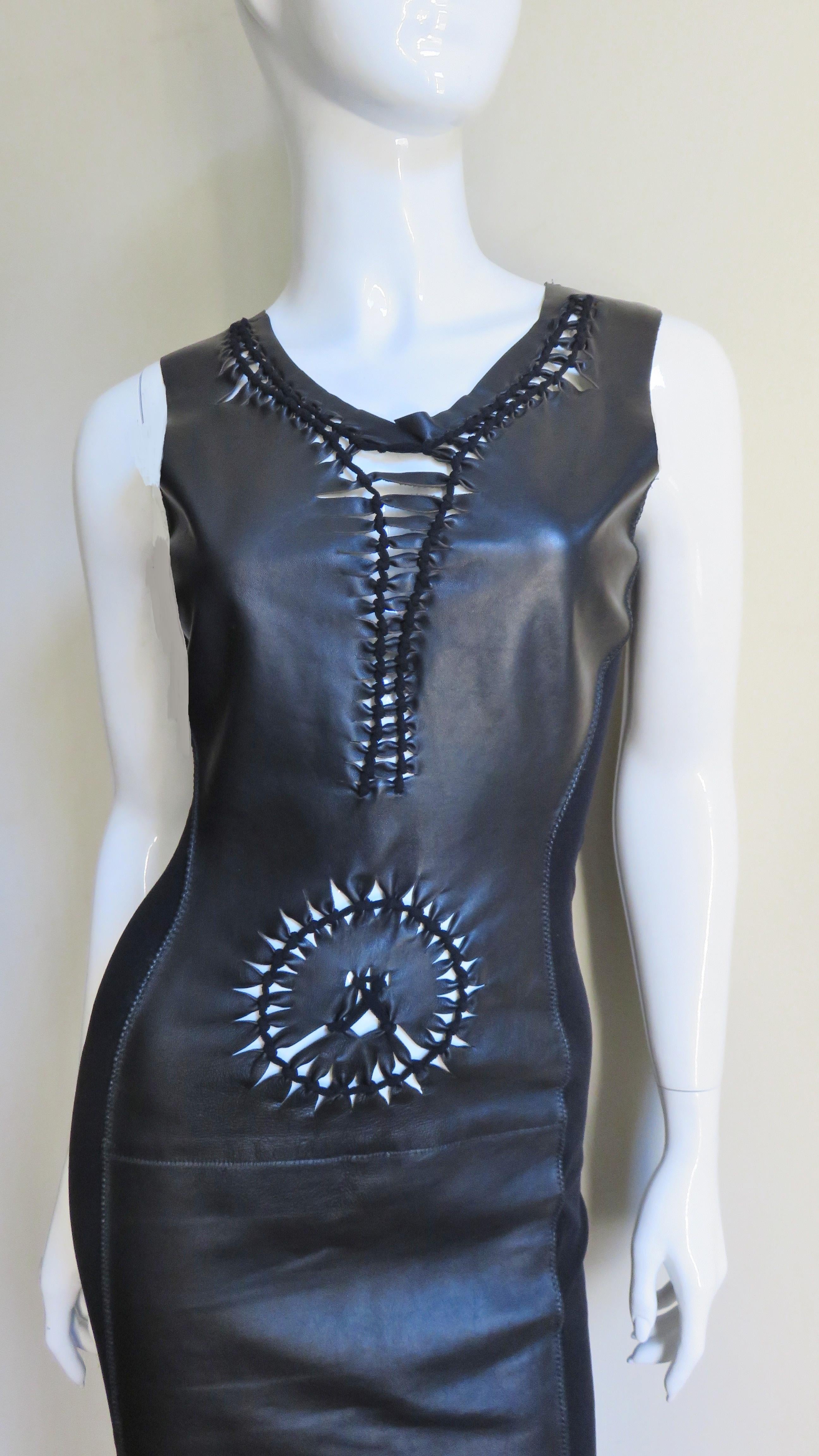 A fabulous black, supple leather dress from Jean Paul Gaultier.   It is sleeveless with a detailed front consisting of leather strips and knots forming a circle at the waist and highlighting a V neckline.  The back and sides of the dress are made of