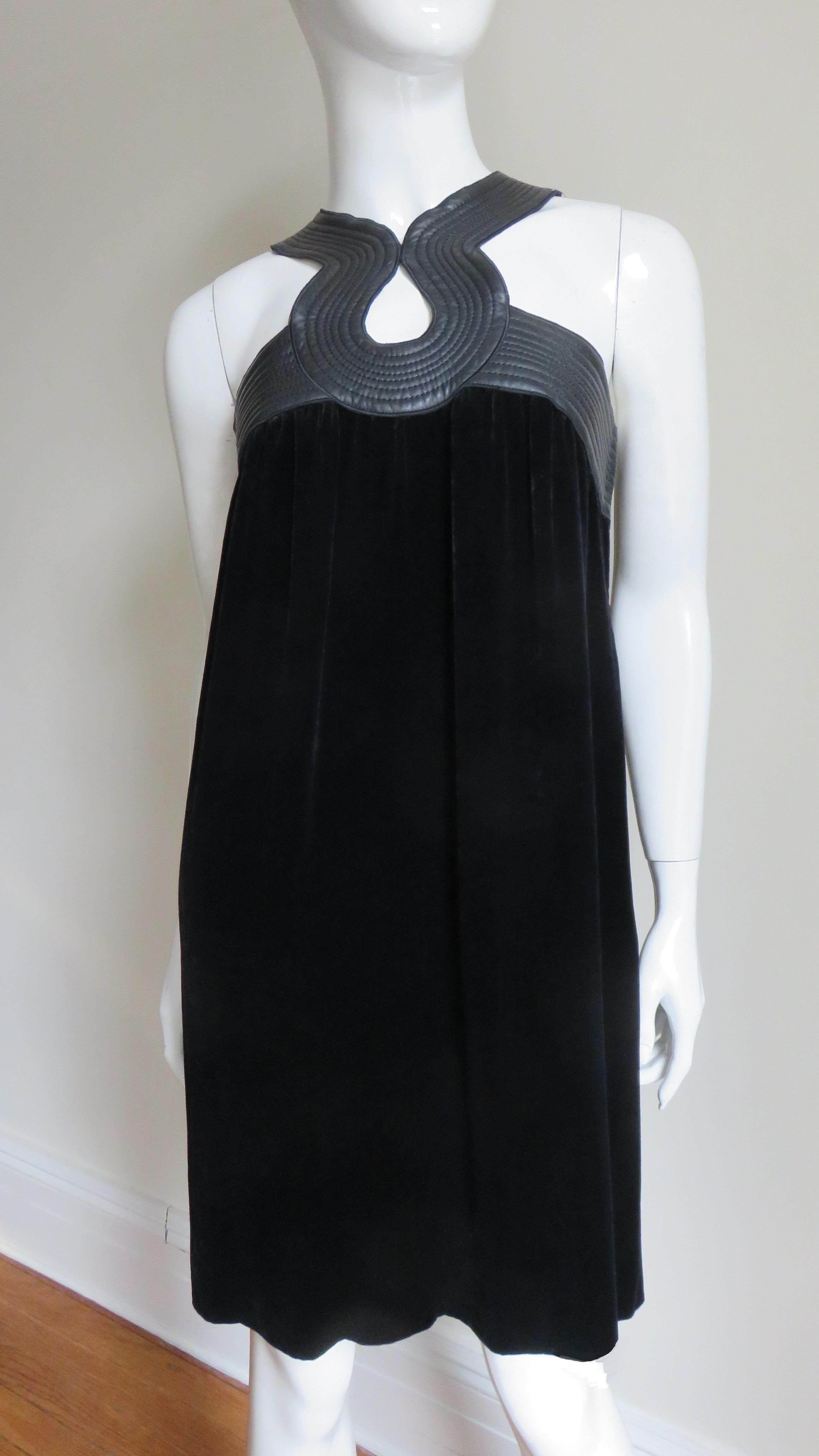 A fabulous black silk velvet dress from Jean Paul Gaultier.  It has incredible topstitched leather trim around top of the dress and neck creating tear drop shaped cut outs in the front and mid back.  It is unlined, closes with a side zipper and