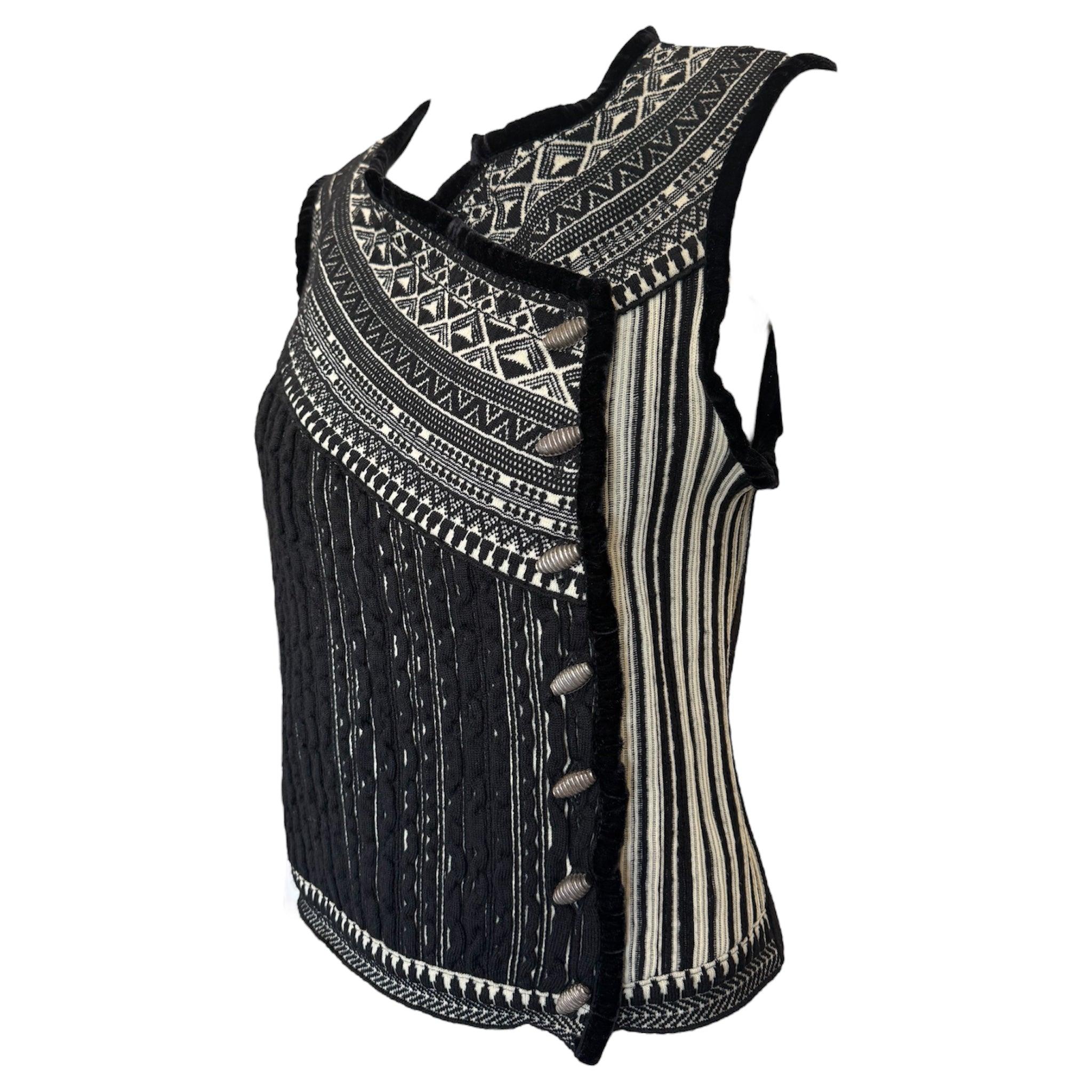 Jean Paul Gaultier, Chaleco jersey Maille Femme. Texturas y motivos contrastados en la misma paleta monótona de colores negro y crema. Botones plateados en el lateral. Excelente estado.

Más información:
Dimensiones:
Etiquetado como talla