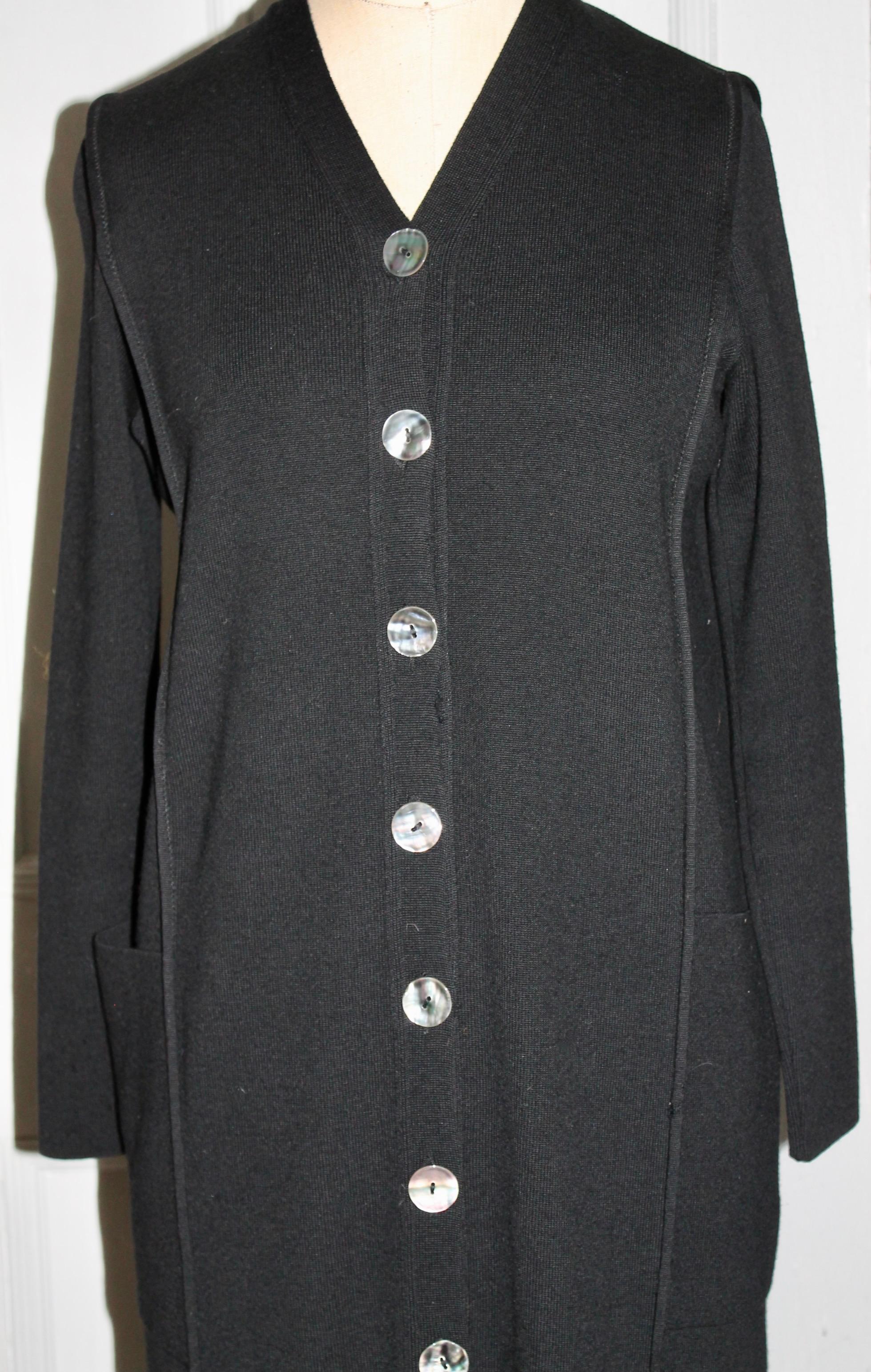 A long black 100% wool day dress. Long sleeves and white buttons down the front with two front pockets.
Size: medium.