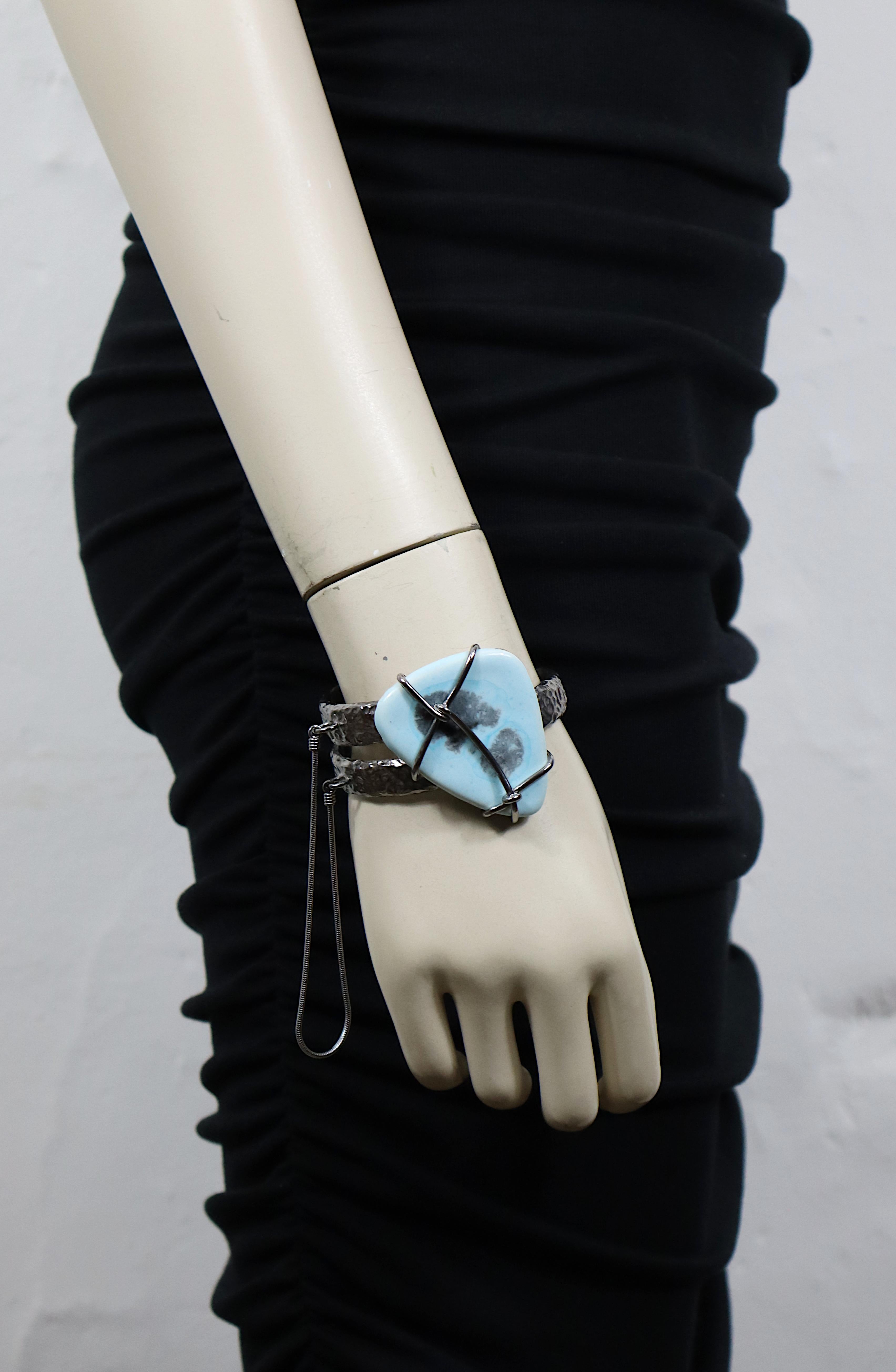 JEAN PAUL GAULTIER hammered ruthenium tone metal cuff bracelet embellished with a free form ceramic pebble and snake chain.

Embossed JEAN PAUL GAULTIER.

Indicative measurements : inner measurements approx. 6 cm x 4.5 cm (2.36 inches x 1.77 inches)