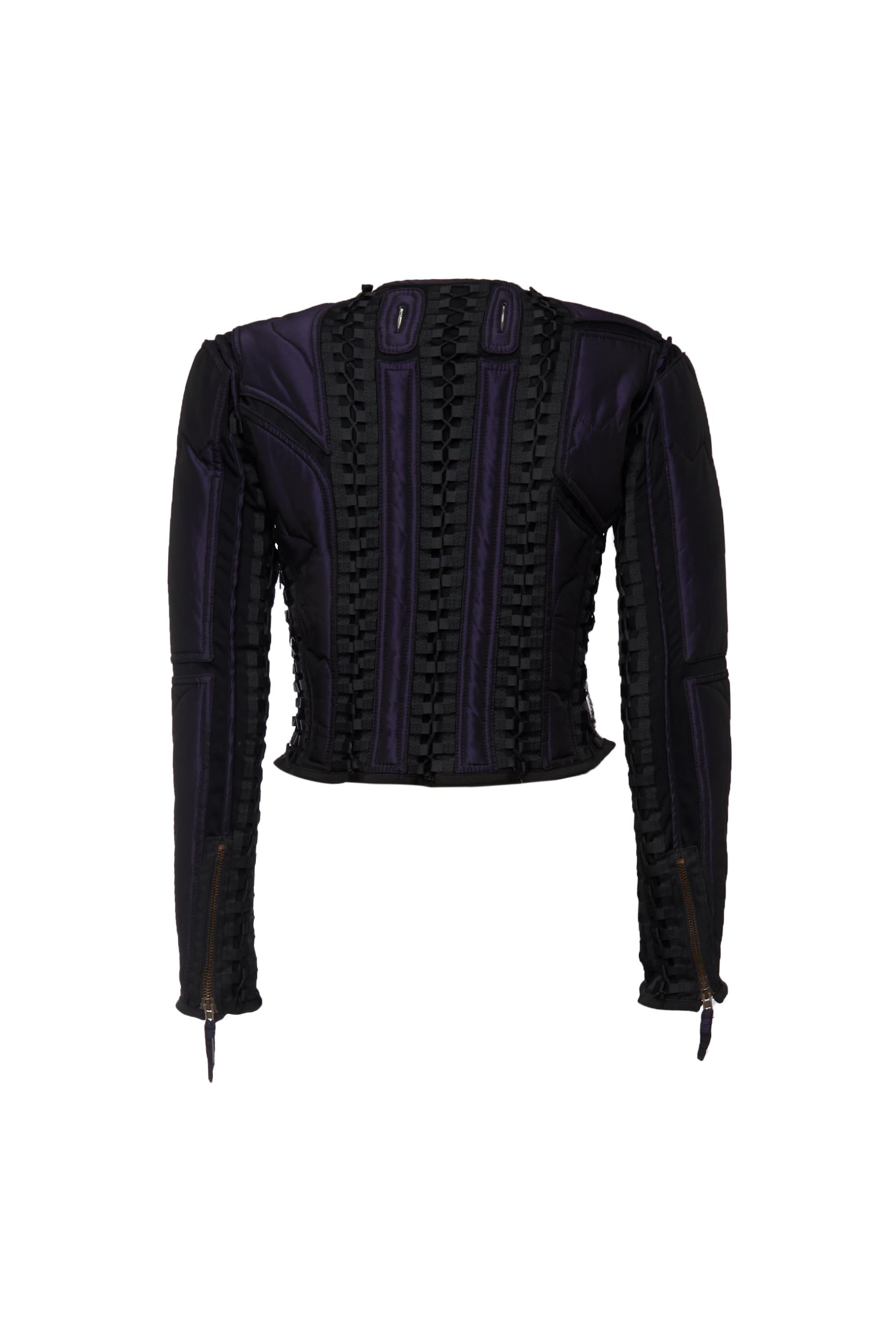 The Jean Paul Gaultier iridescent nylon jacket with all-over lacing details from the early 2000s is a distinctive piece that reflects the designer’s avant-garde approach to fashion. This jacket features an iridescent purple nylon fabric,